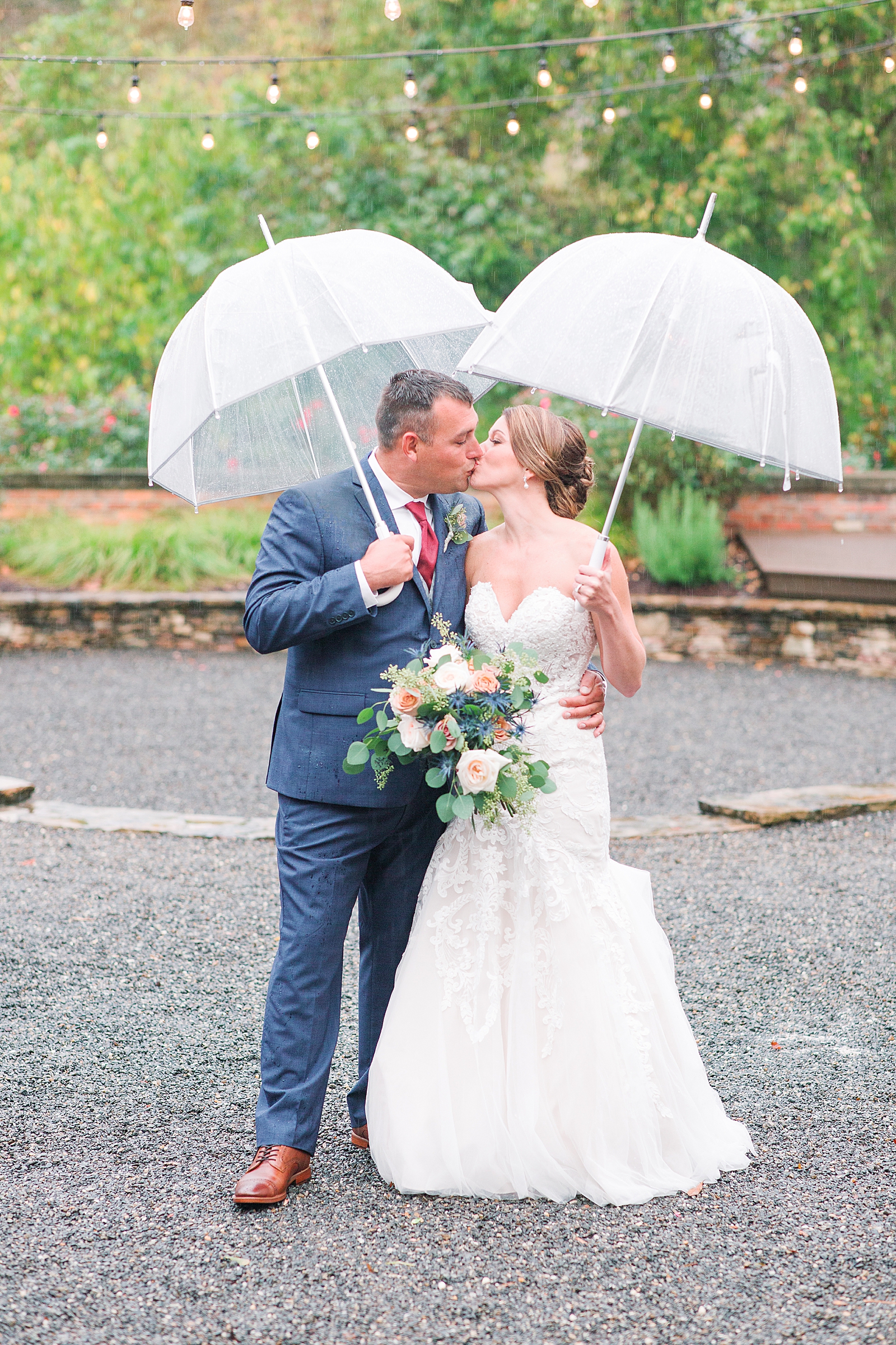 The Hackney Warehouse Bride and Groom Kissing Under Umbrellas in The Rain Photo