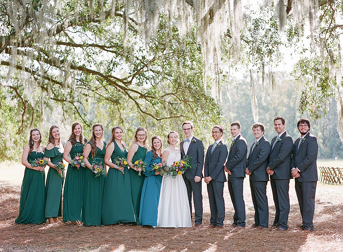 Bride and Groom with Large Bridal Party Under Trees at Hewitt Oaks Photo 