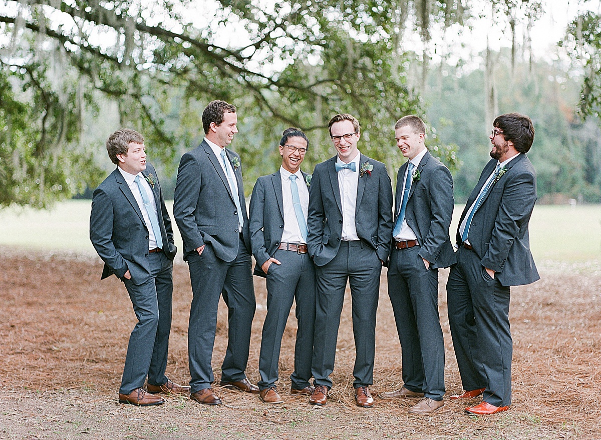 Michael Laughing with his Groomsmen Under Trees Photo 
