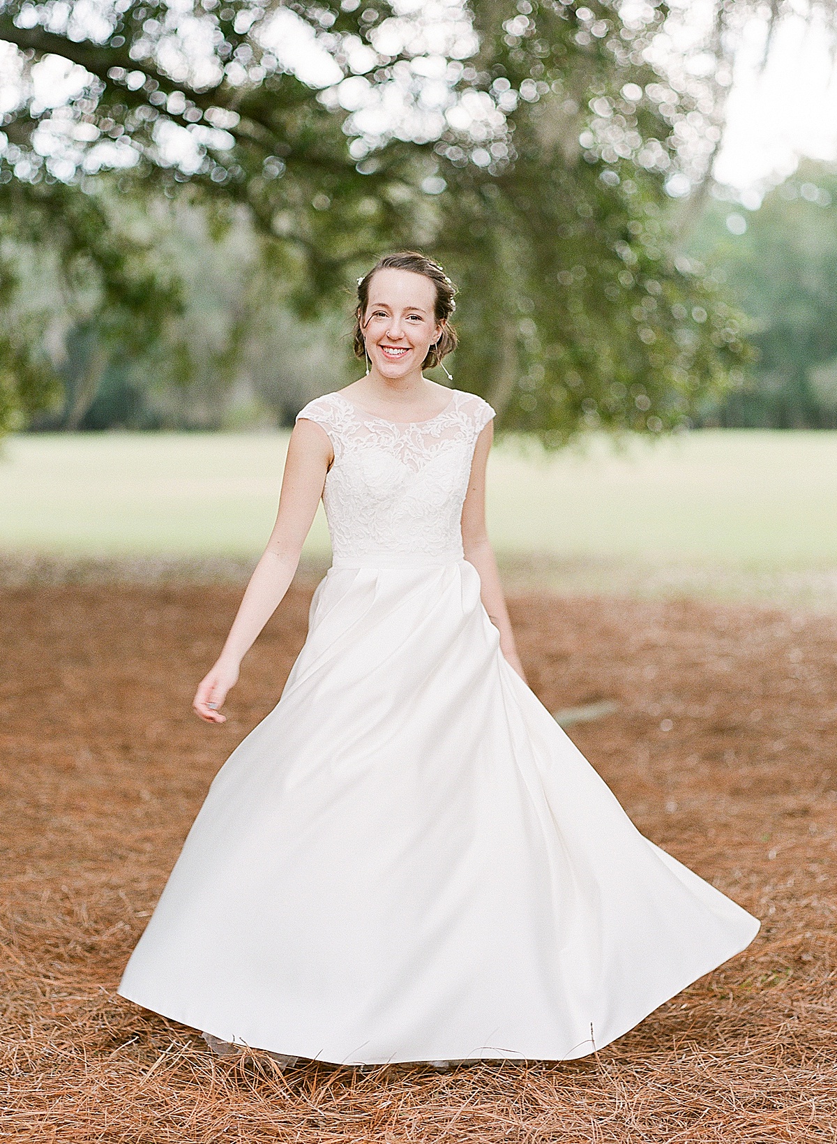 Bride Twirling in Dress Under Trees at Hewitt Oaks Wedding Photo 