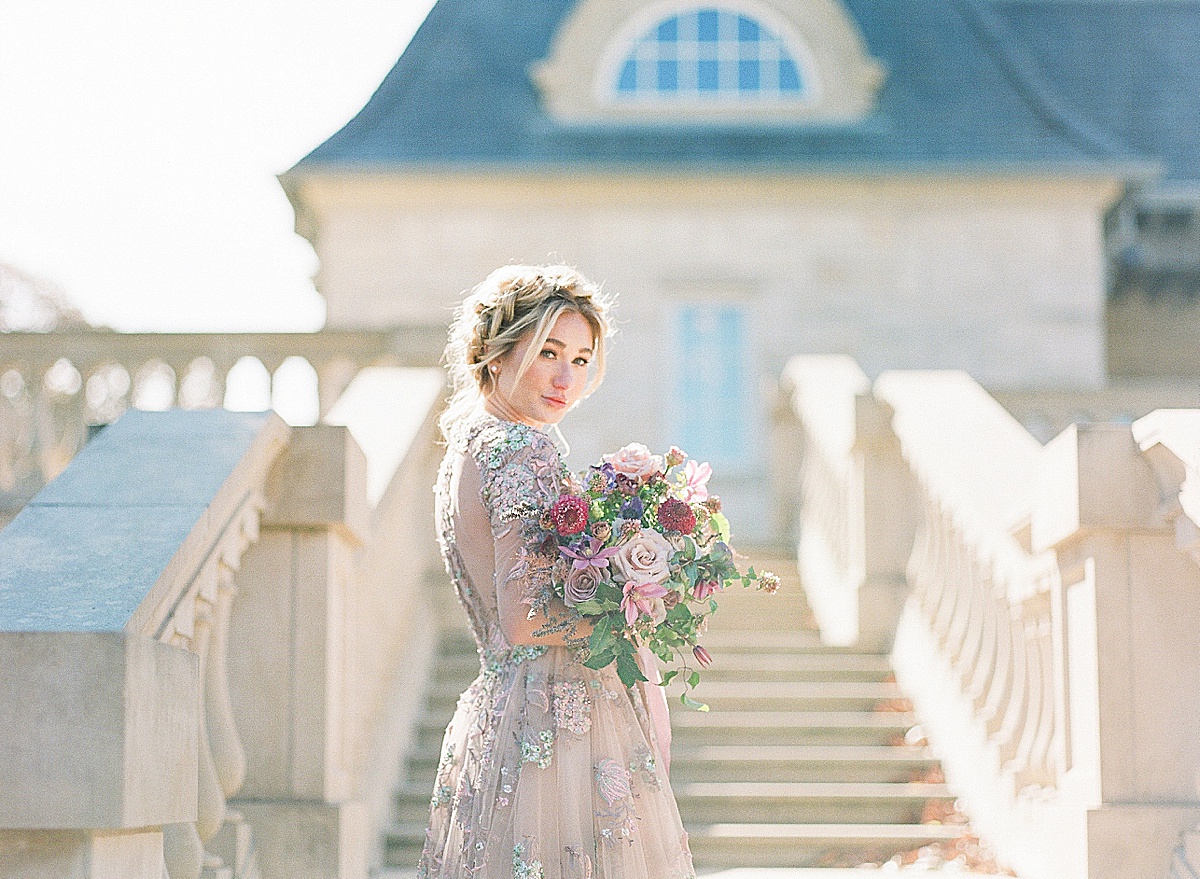 Bride Looking down stairs in Lavender Wedding Dress holding bouquet Photo 