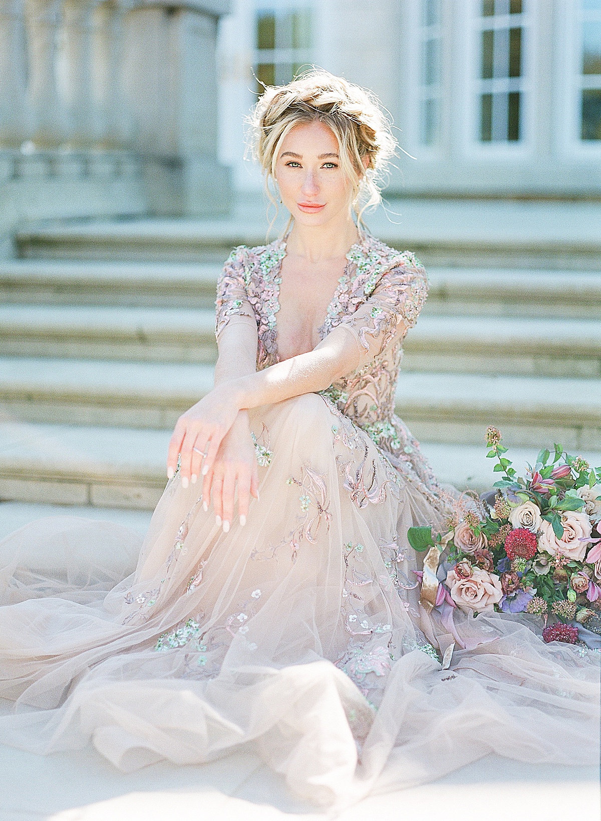 Lavender Wedding Dress Inspiration Session Bride looking at camera sitting on stairs with arms on her knees photo