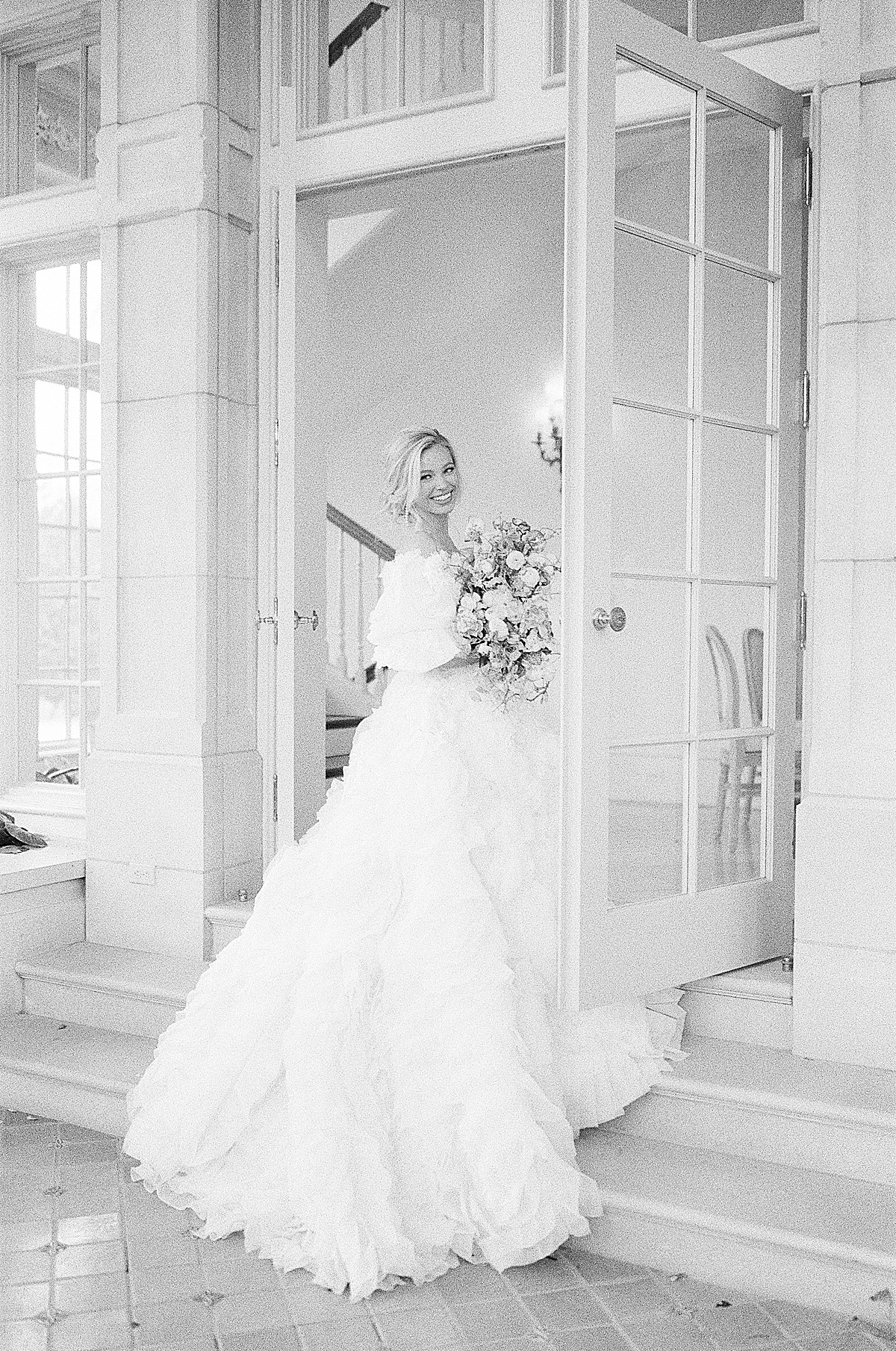 Black and White of Bride on Stairs Looking Over Her Shoulder Photo