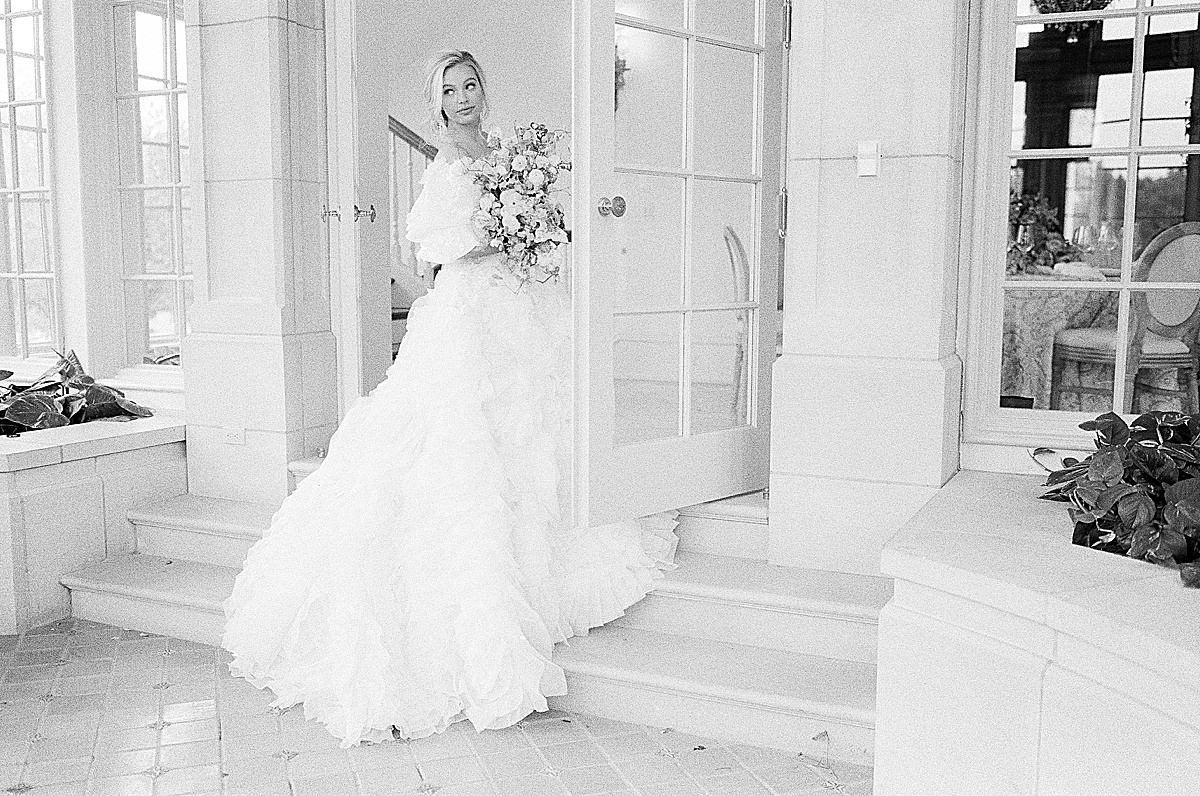 Black and White of Bride on Stairs Looking Over Her Shoulder Photo