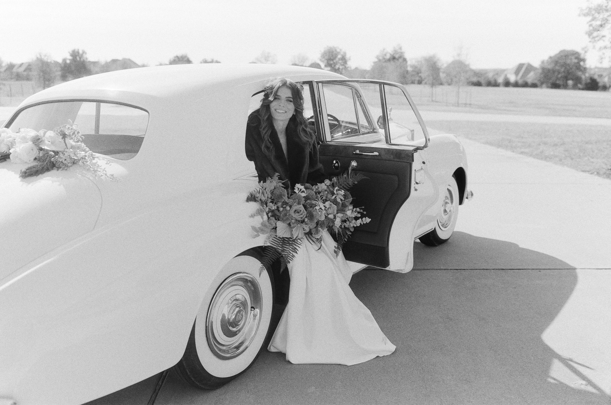 Black and White of Bride Sitting in Vintage Rolls Royce Car