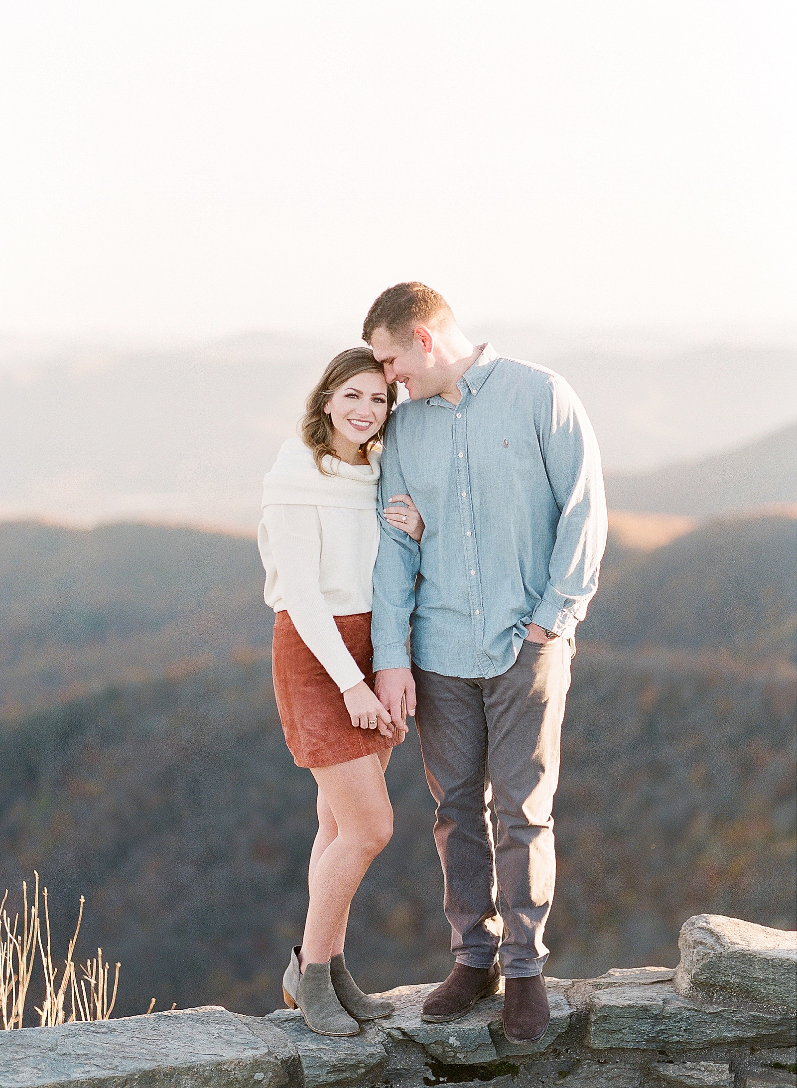 How To Have The Best Craggy Gardens Engagement Photos Couple Snuggling With Mountains In The Background Photo