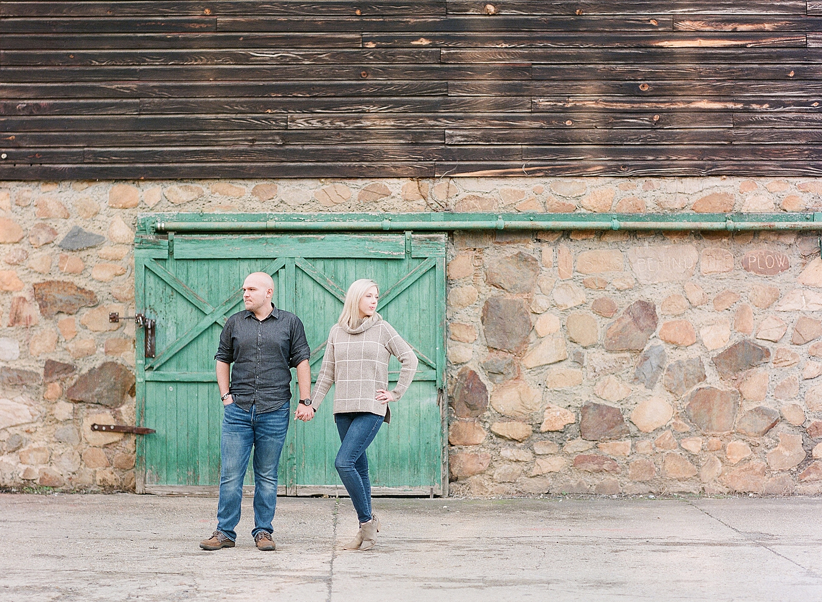 Couple Looking Off Holding Hands In Front Of Green Door Photo