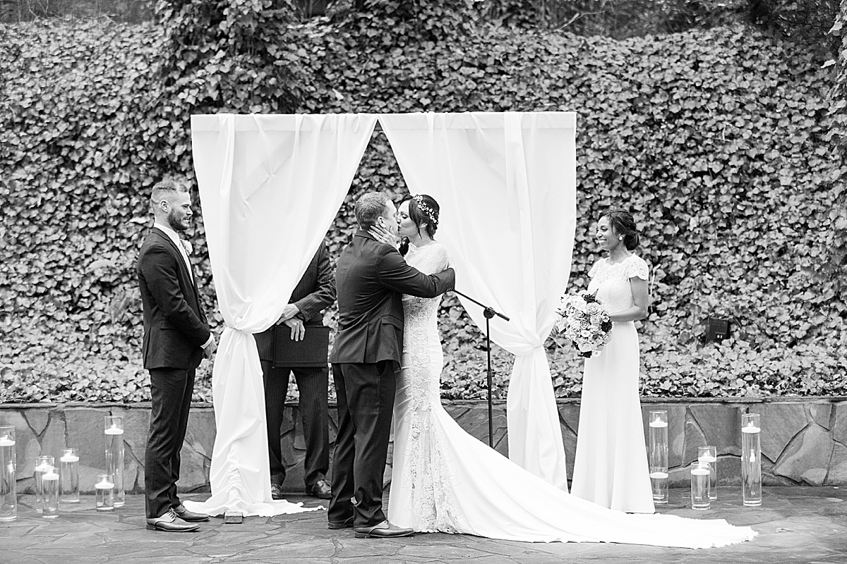 Black and White NC Wedding Venue Creekside Ceremony Couples First Kiss Photo 