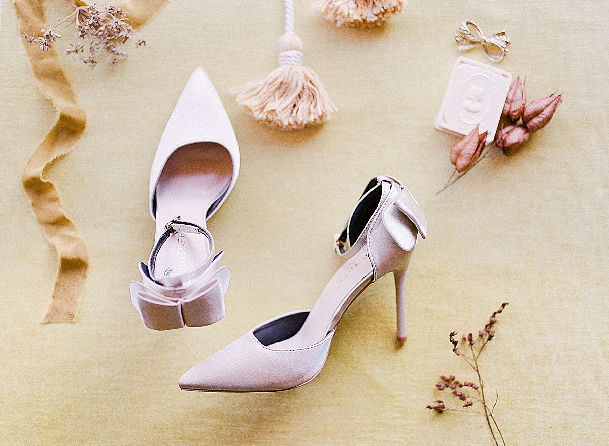 Flat Lay of Pink High Heels With Ribbons Tassels and Dried Flowers Photo