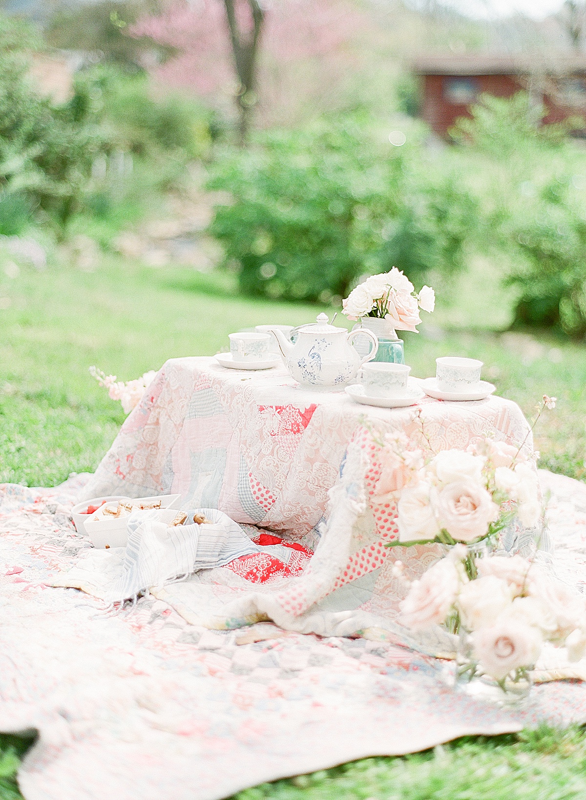 Tea Party Table On the Ground With Quilts and Flowers Photo