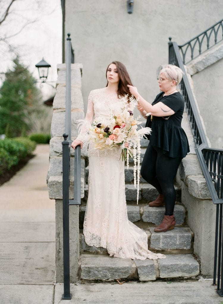 Leah Milan Makeup touching up our bride on stairs photo 
