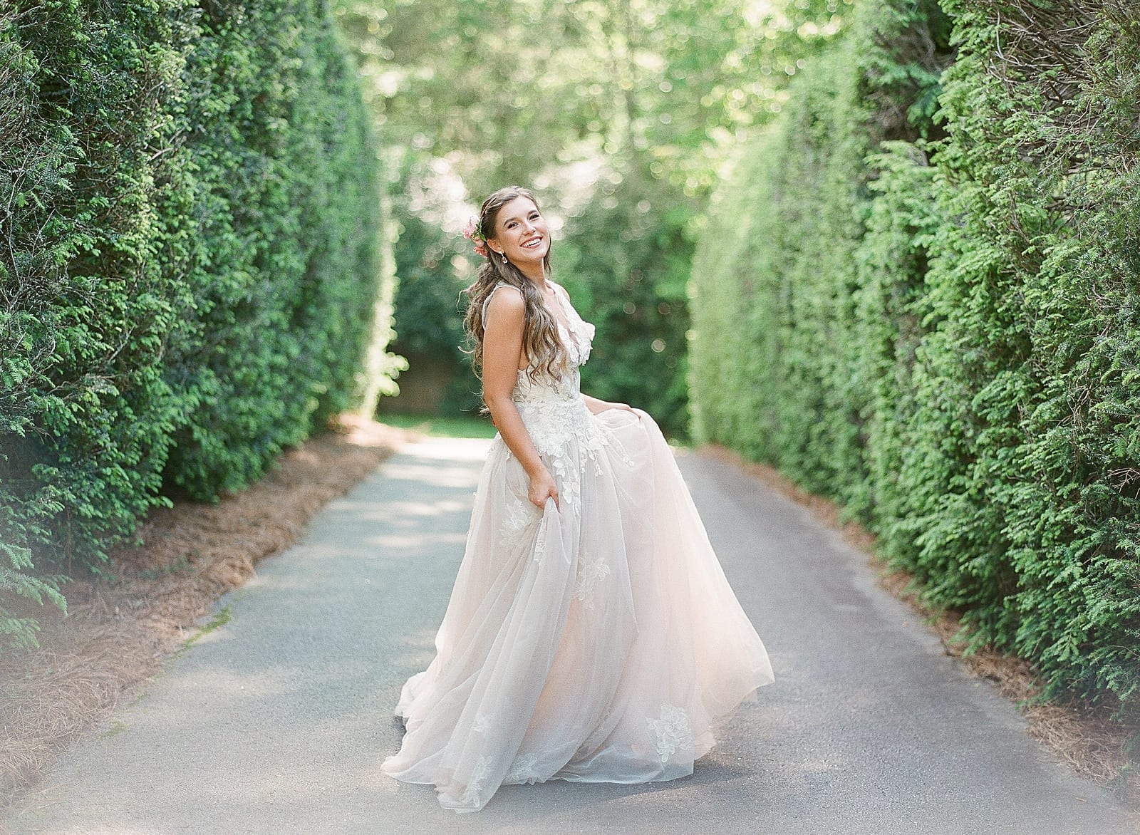 Bride Twirling in Row of Hedges at Old Edwards Inn Photo 