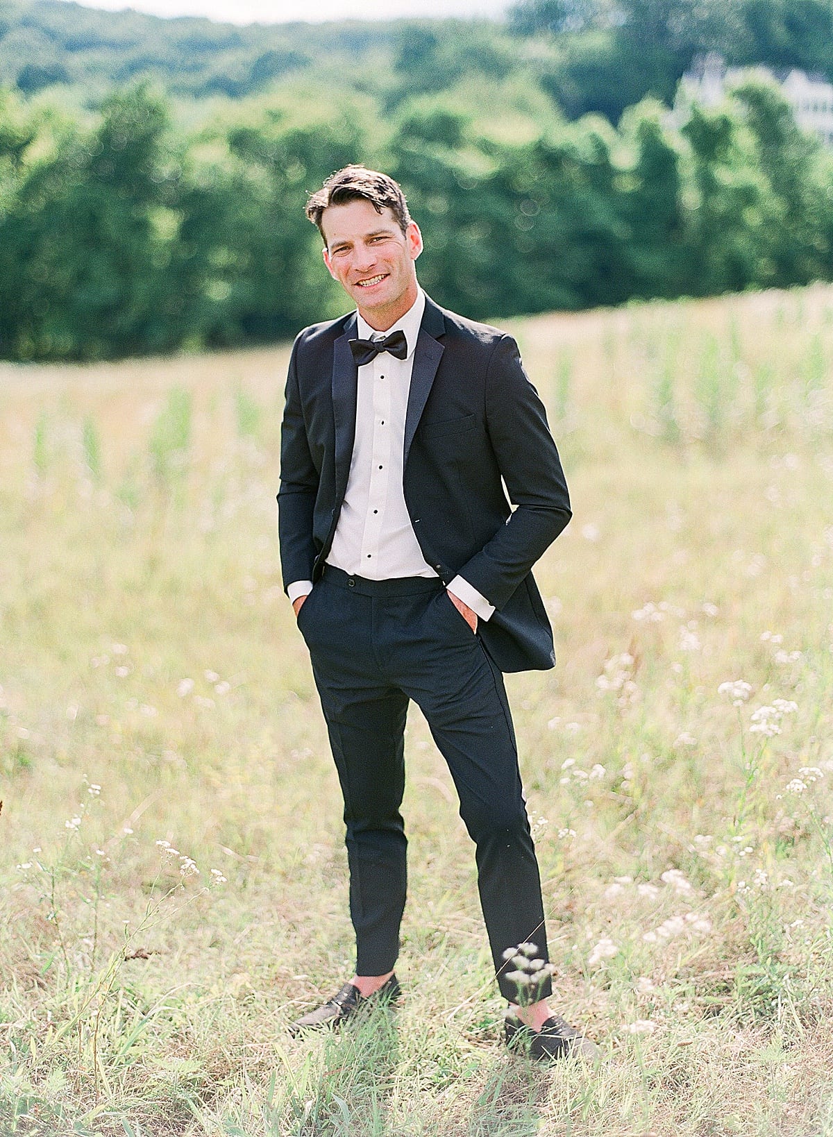 Groom Smiling at Camera in Field Photo