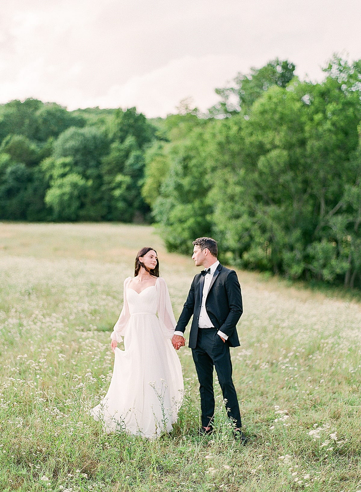 Bride and Groom at Bloomsbury Farm Holding Hands in Field Photo