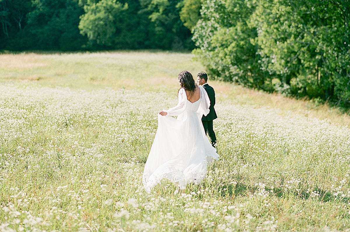 Bride and Groom walking through field at Bloomsbury Farm