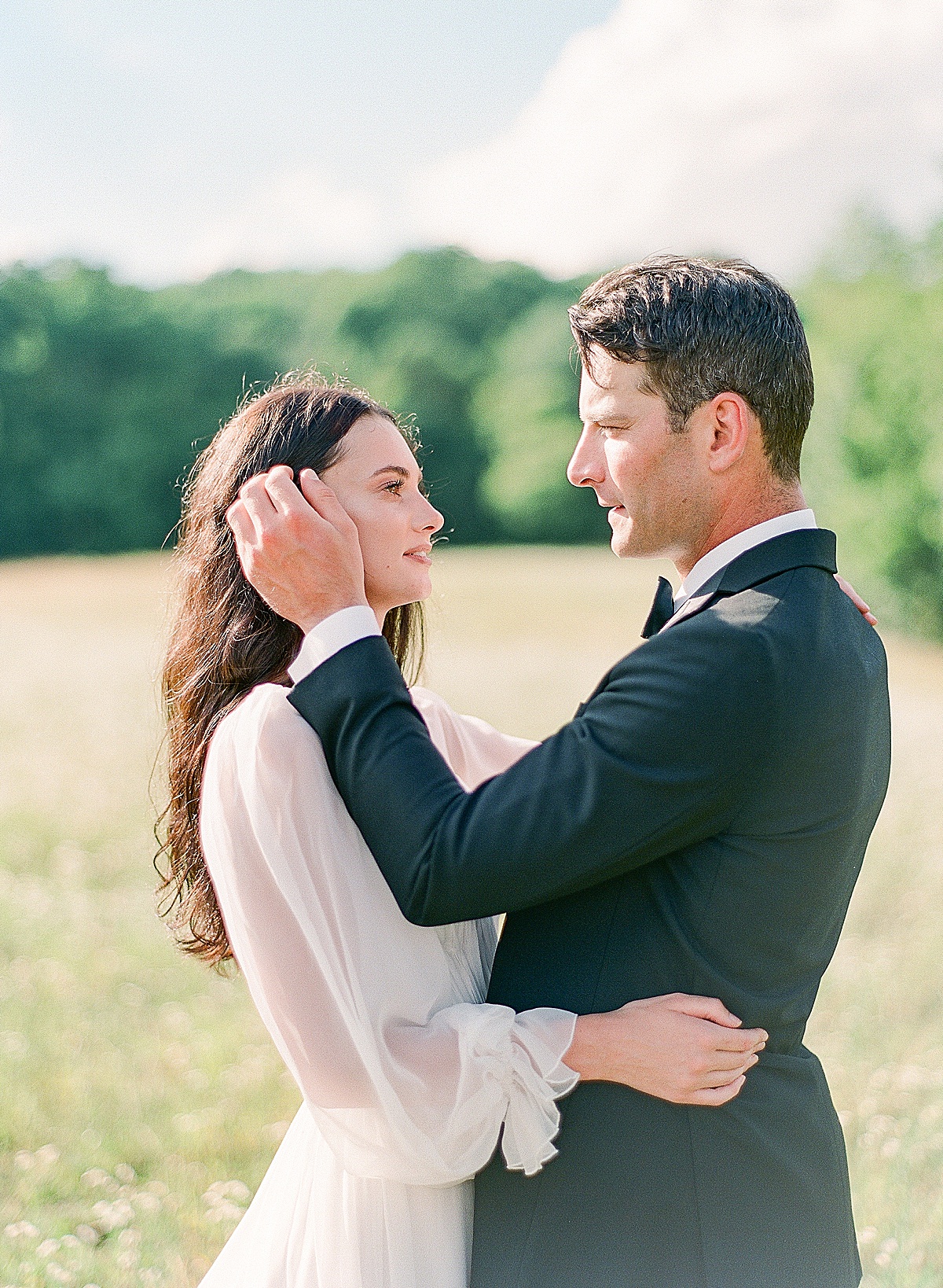 Bride and Groom looking at each other in field