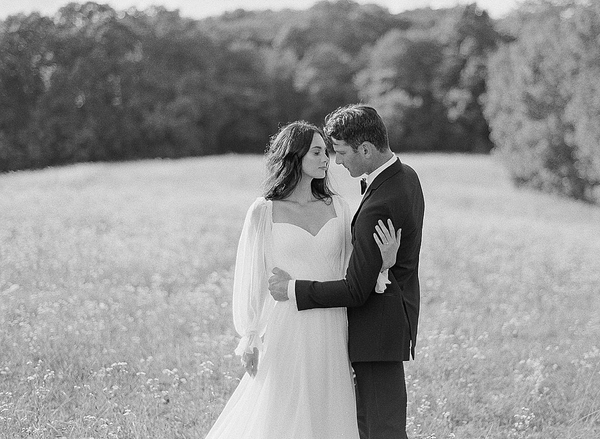 Black and white of Bride and Groom Hugging in field photo
