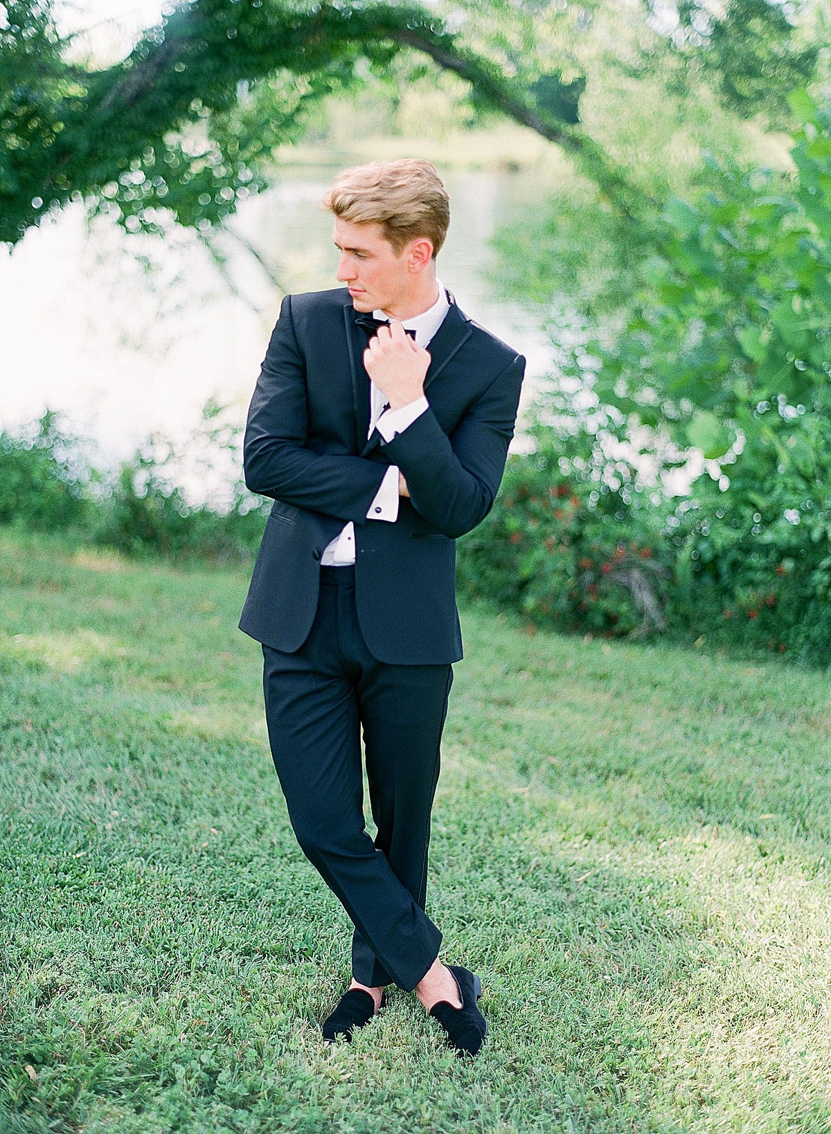 Groom with Feet Crossed Messing with Bow Tie Photo 