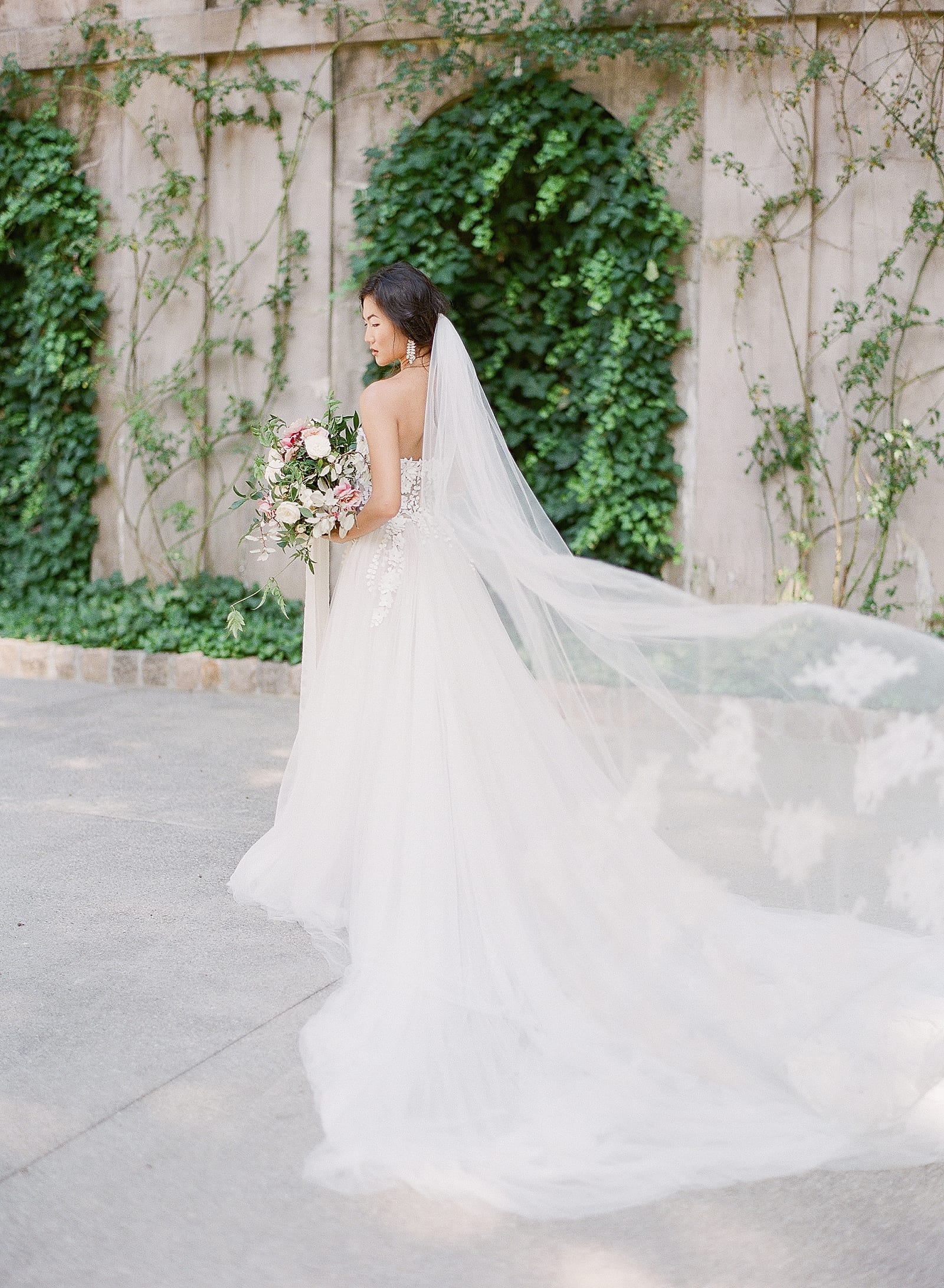 Bride in Dana Harel Wedding Gown and flowing veil photo