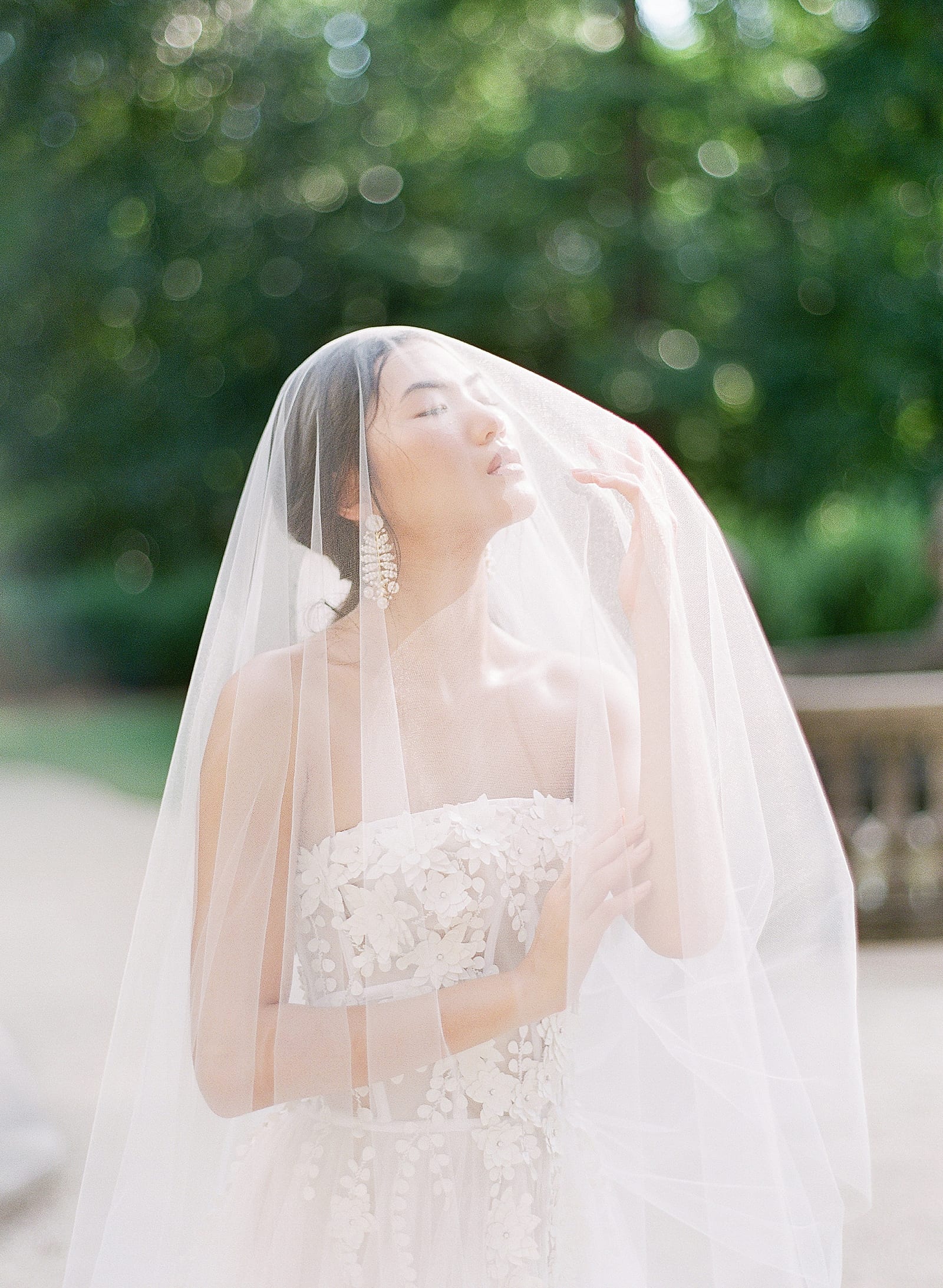 Bride under veil looking up in Dana Harel Design Gown Photo