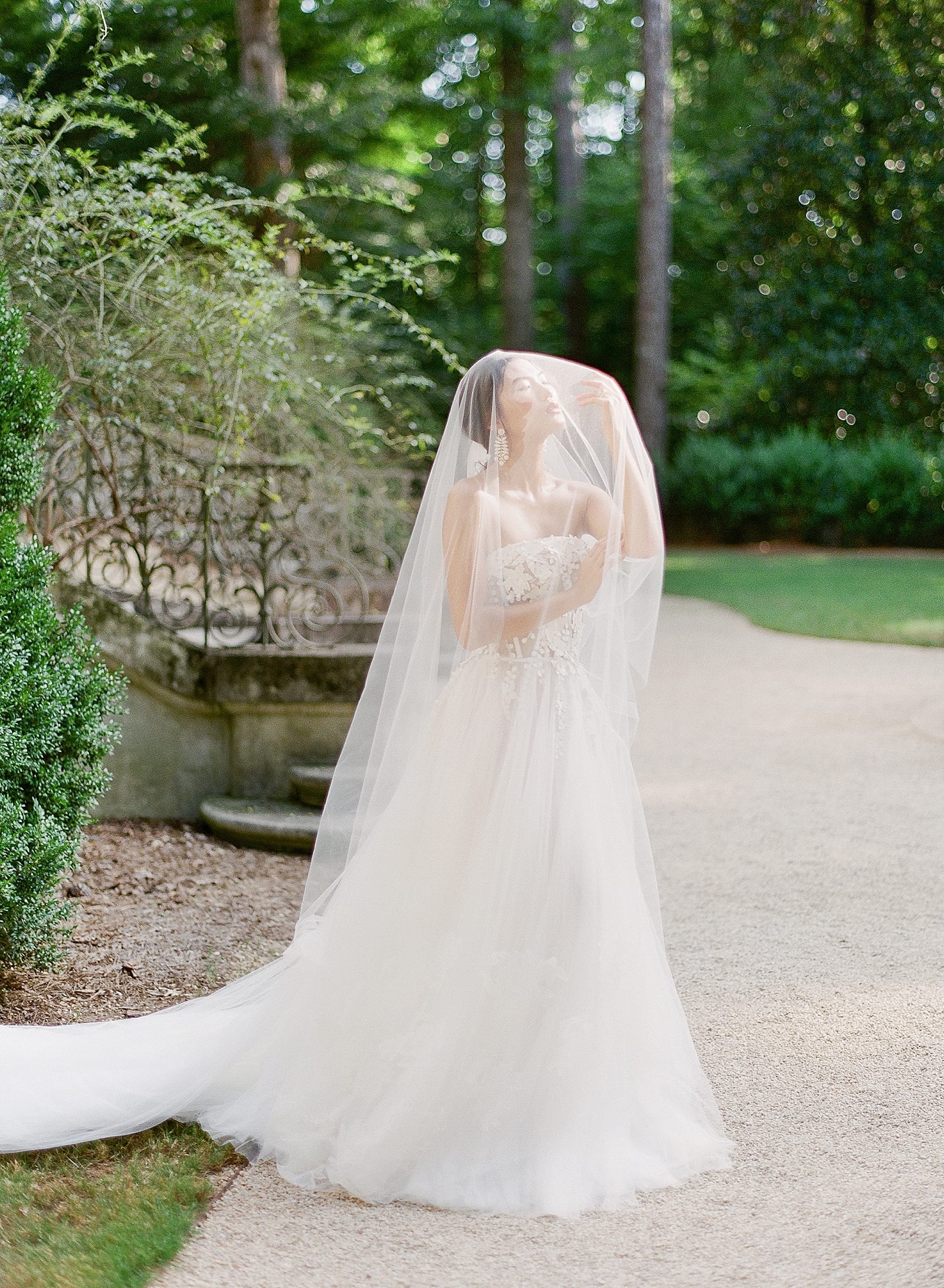 Bride in Wedding Dress with veil over head photo