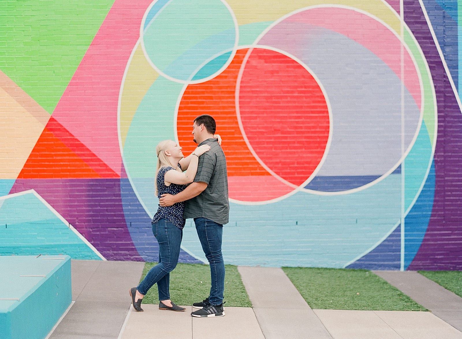 Downtown Raleigh NC Couple hugging in front of colorful wall photo