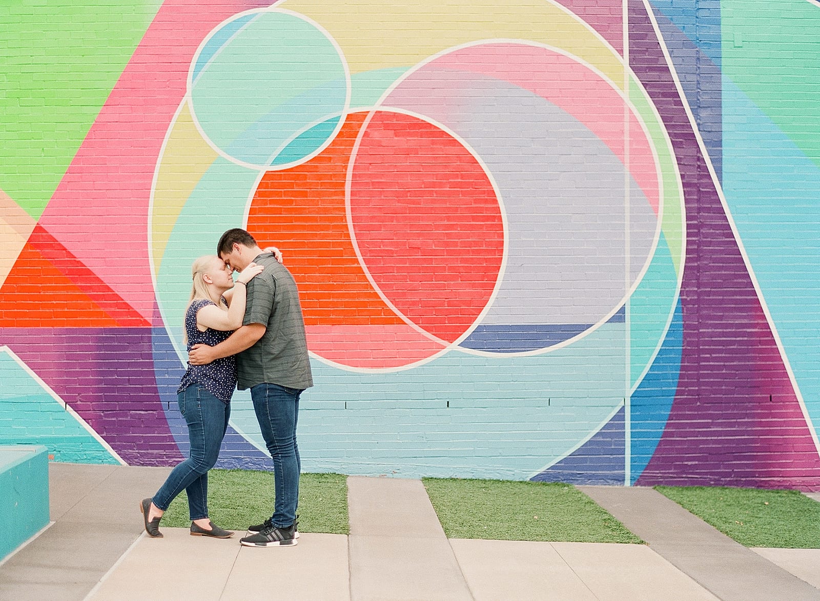 Downtown Raleigh NC Couple hugging in front of colorful wall photo