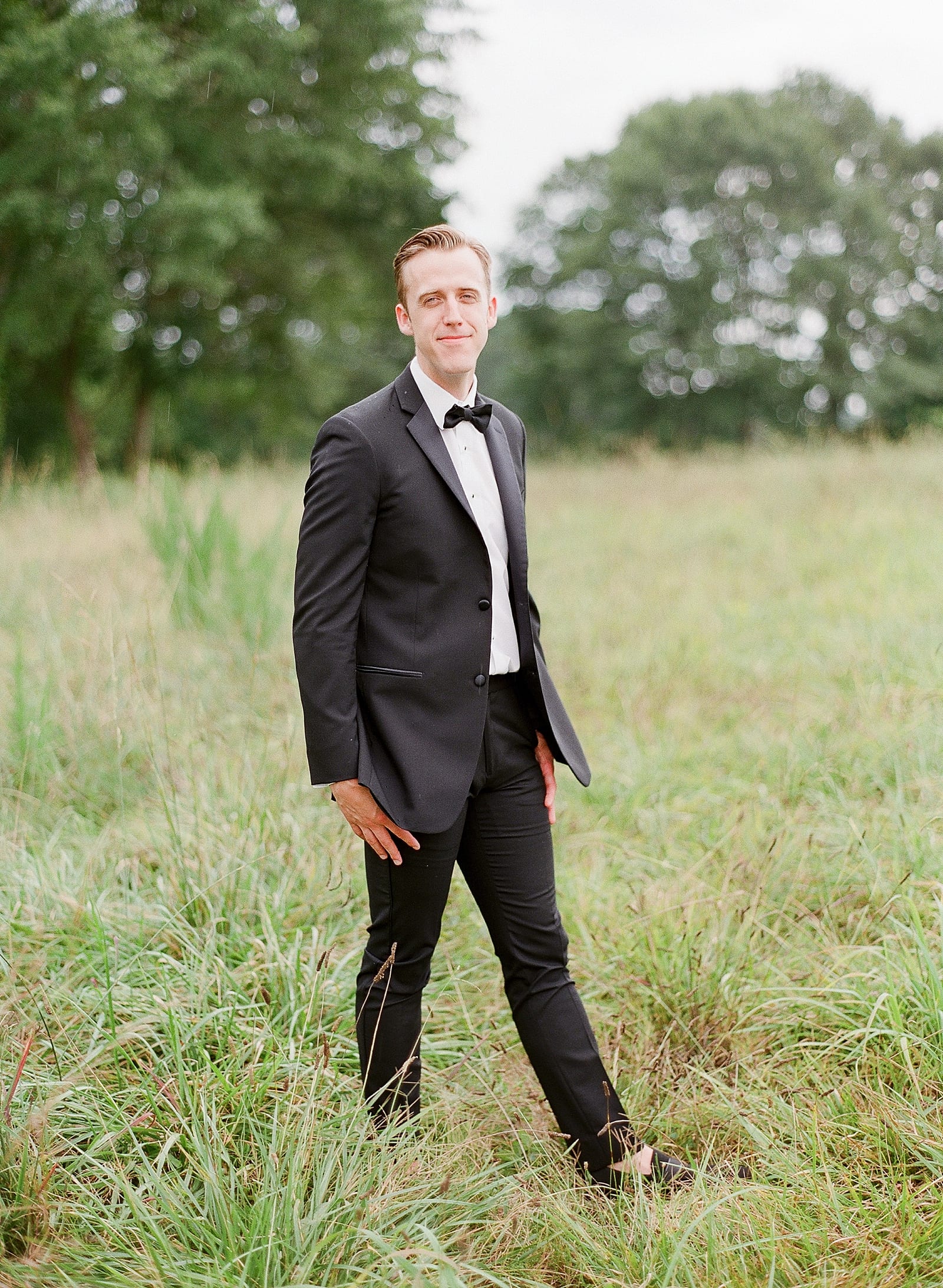 Groom Smiling in Field at Inn at Serenbe Photo