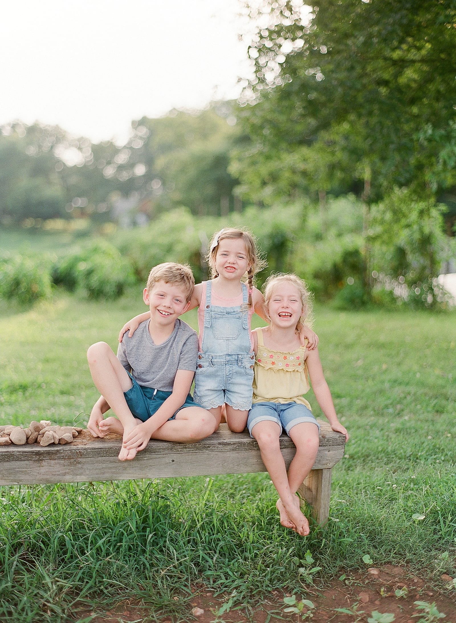 Siblings Sitting on Bench Smiling Photo