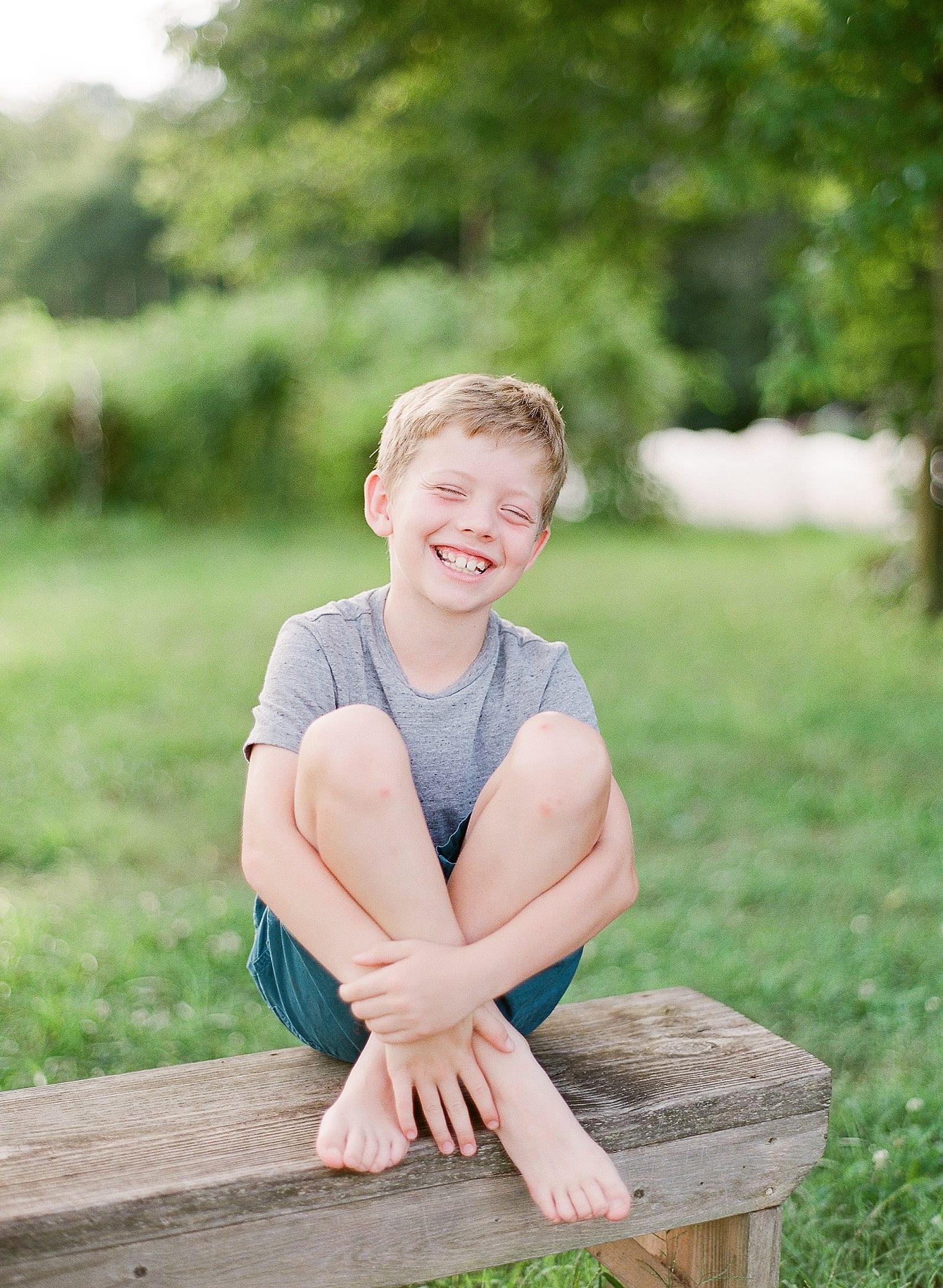 Little Boy Sitting on Bench Laughing Photo