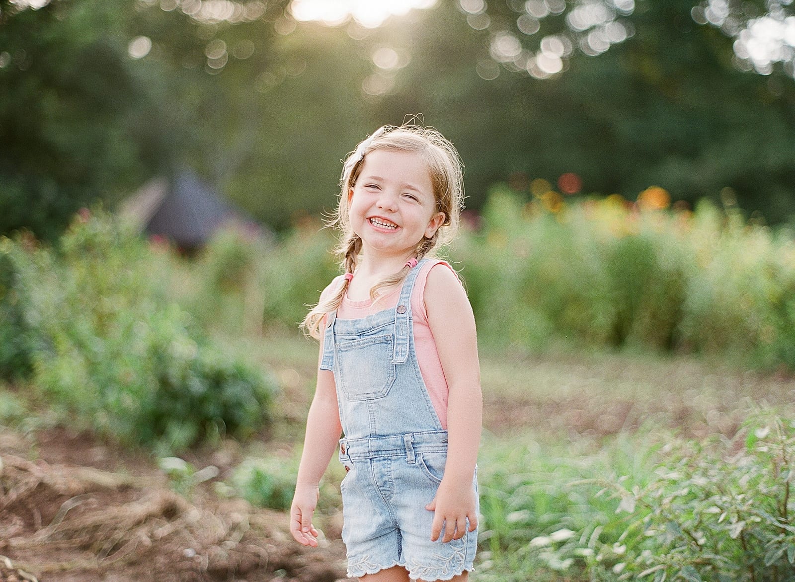 Little Girl In Overalls and Pigtails Laughing at Camera Photo