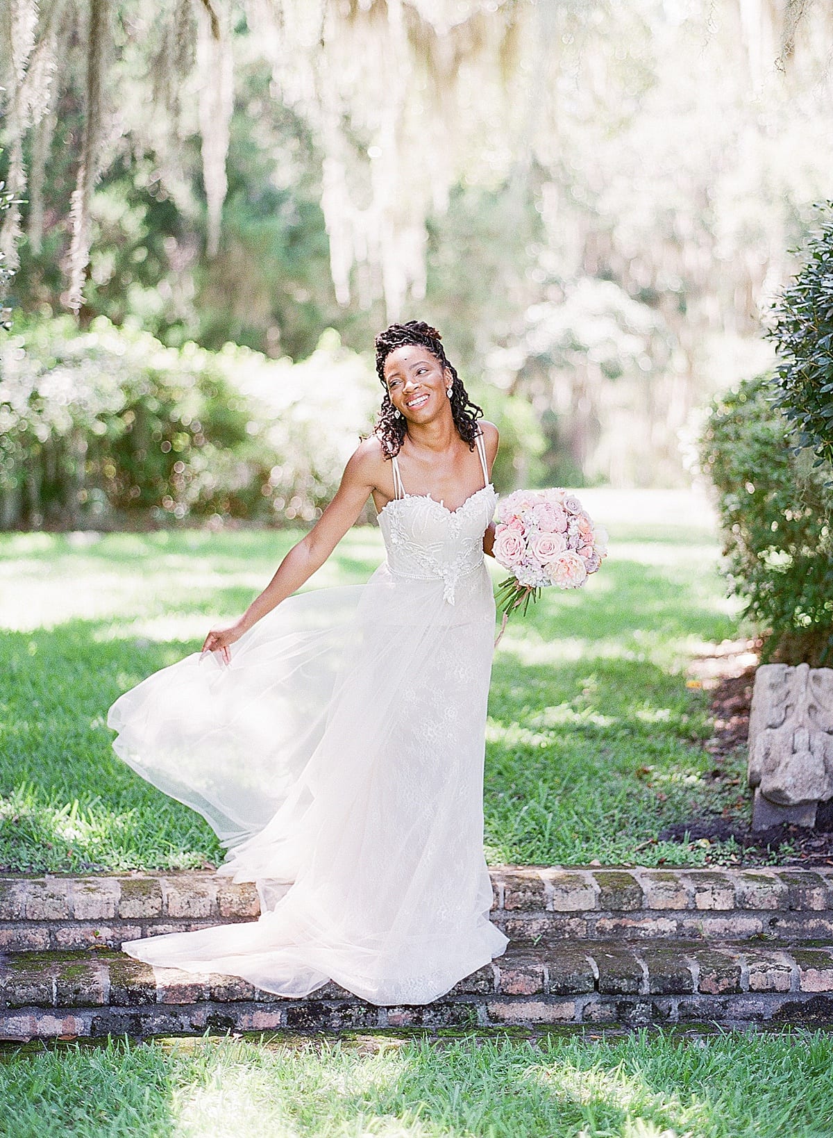 Bride Laughing On Steps Holding Dress and Bouquet Photo 