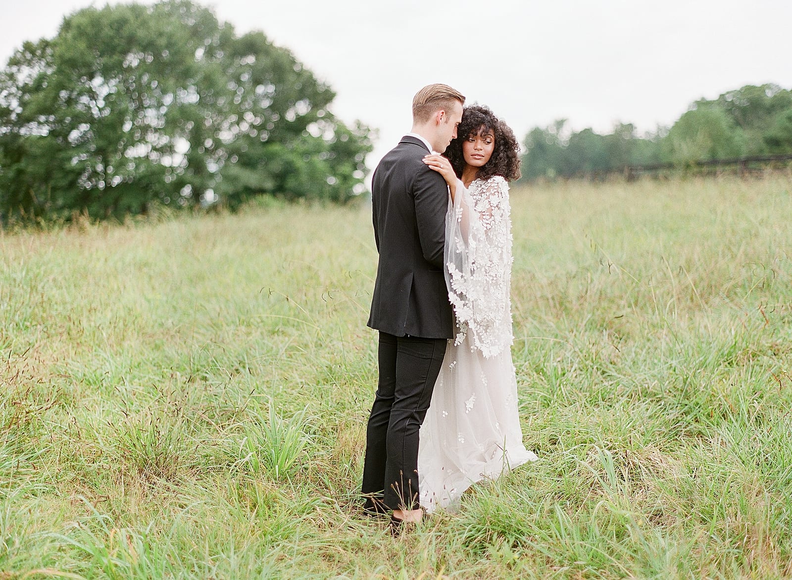 Bride and Groom Hugging in field photo