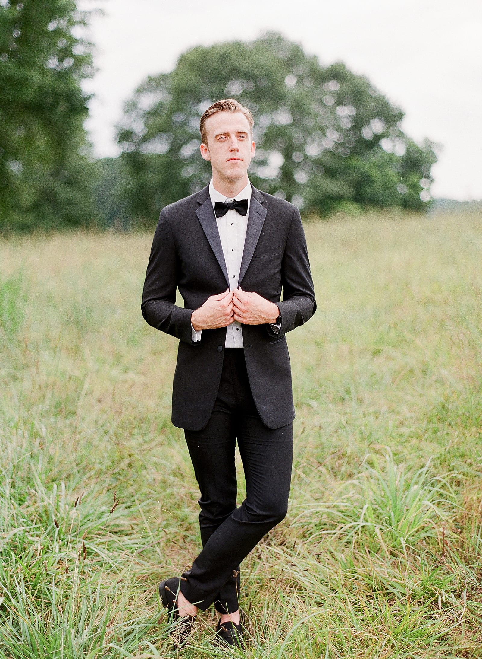 Groom with Feet Crossed Holding Jacket Photo