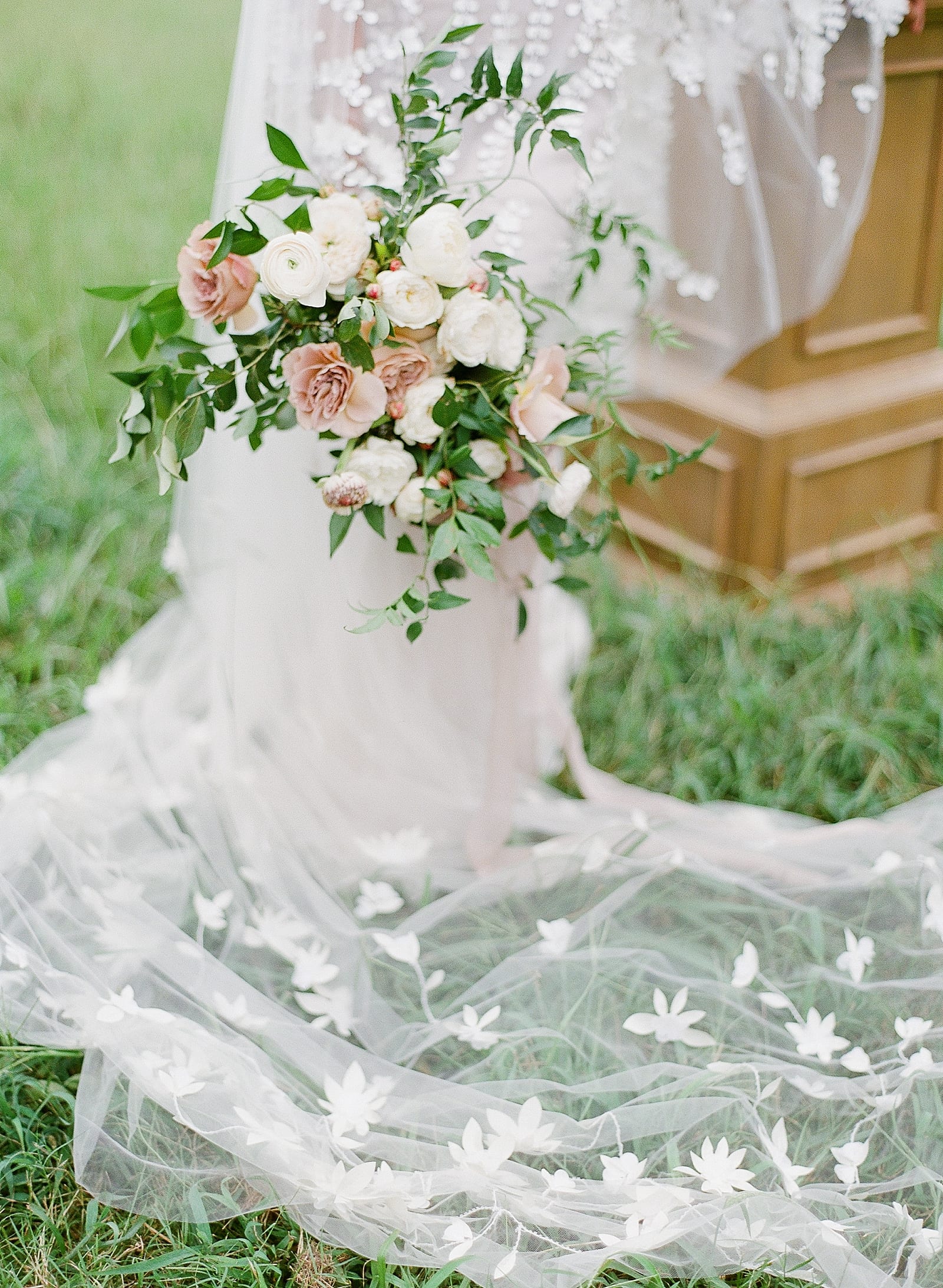 Bride Holding Bouquet with Veil on Ground Photo