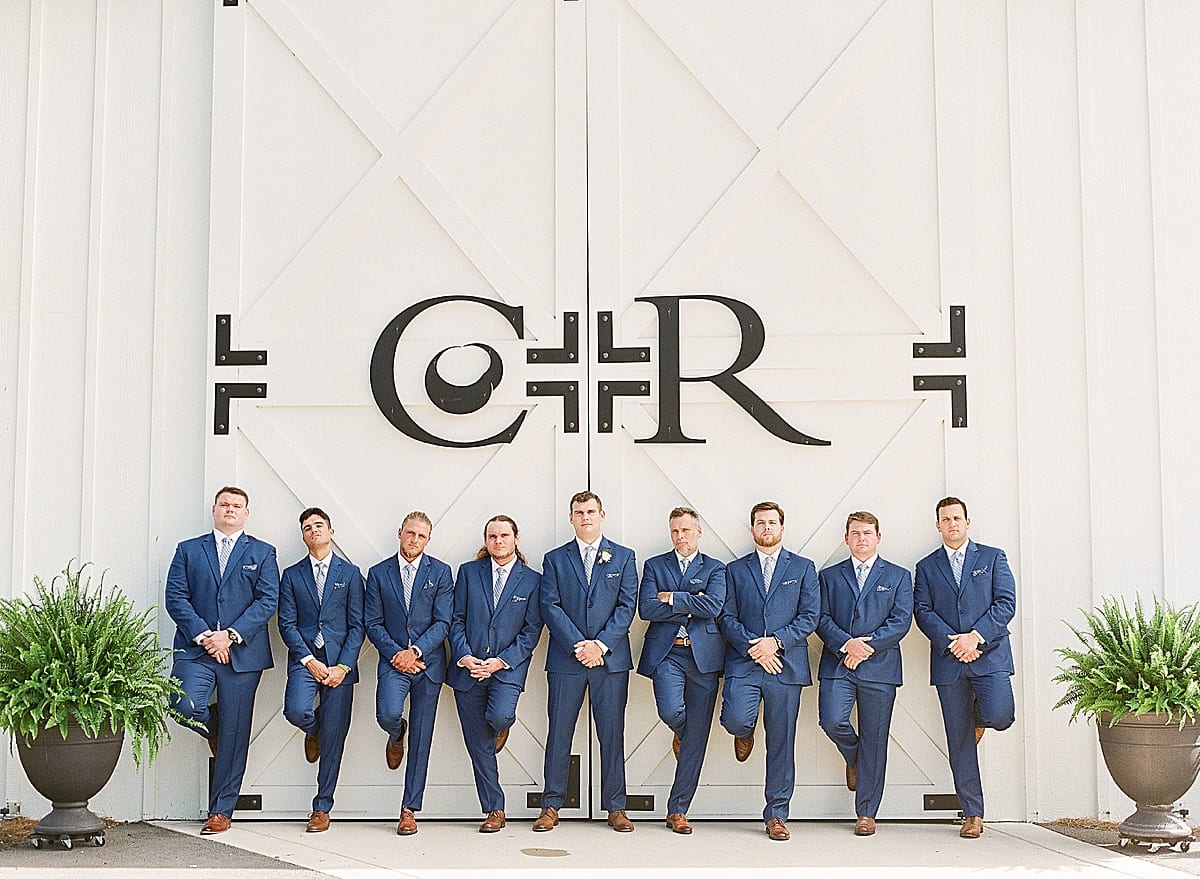 Groom with Groomsmen Leaning On Building Photo