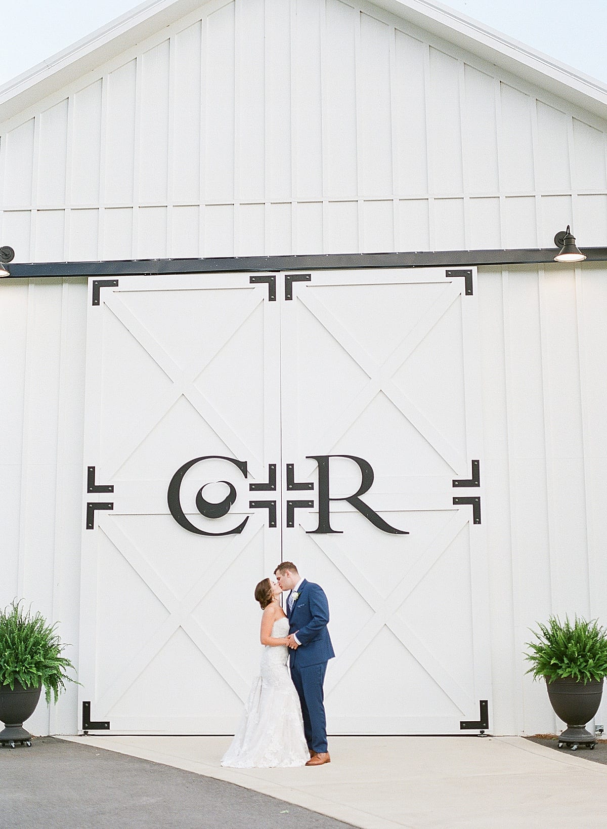 Chestnut Ridge Bride and Groom Kissing Under Logo Photo