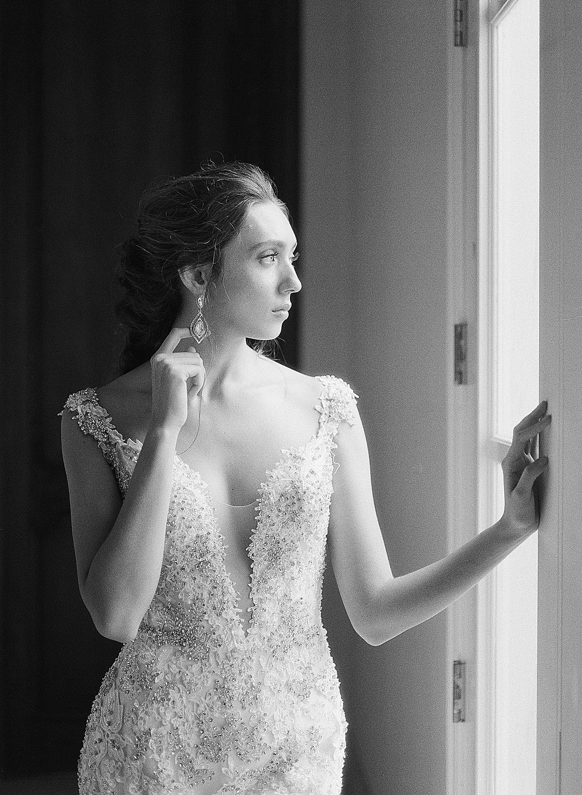 Black and White of Bride Looking Out Window at Wedding Venue in Houston Photo