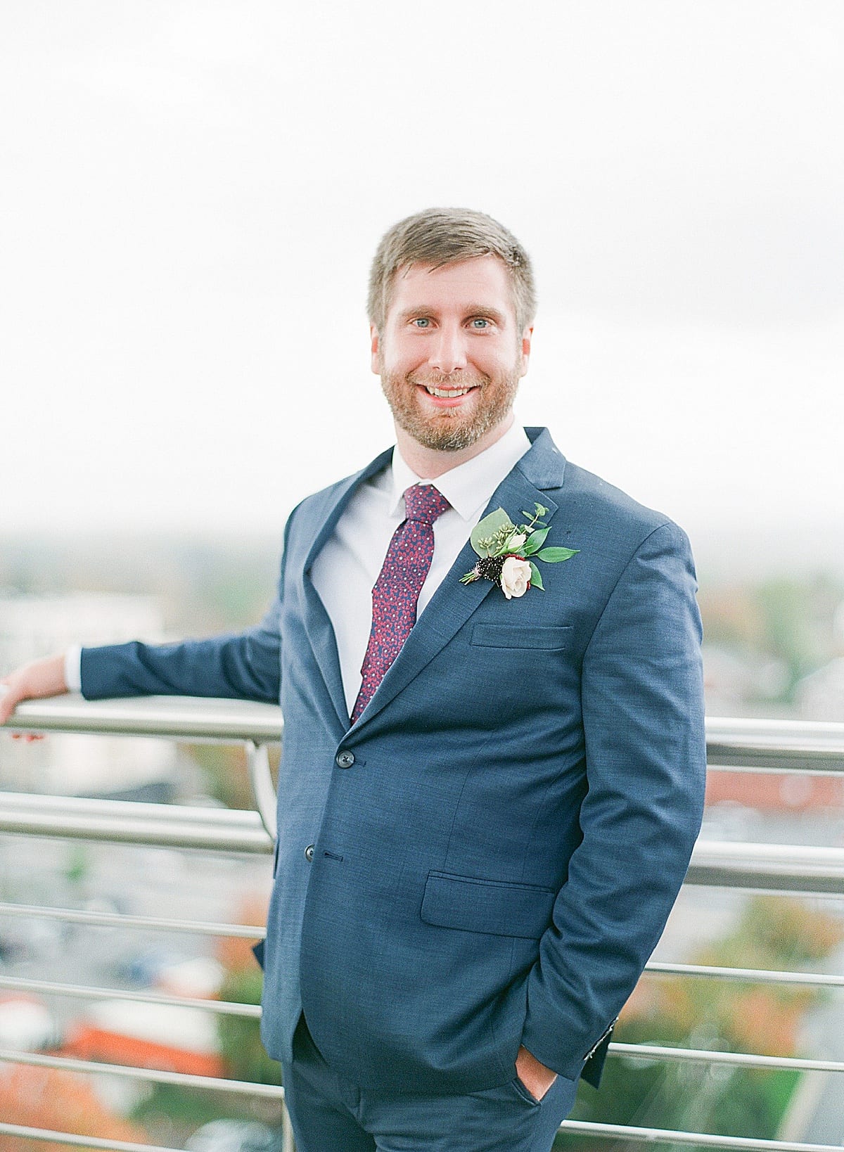 Asheville Capital Club Wedding Groom Leaning on Rail Smiling at Camera Photo