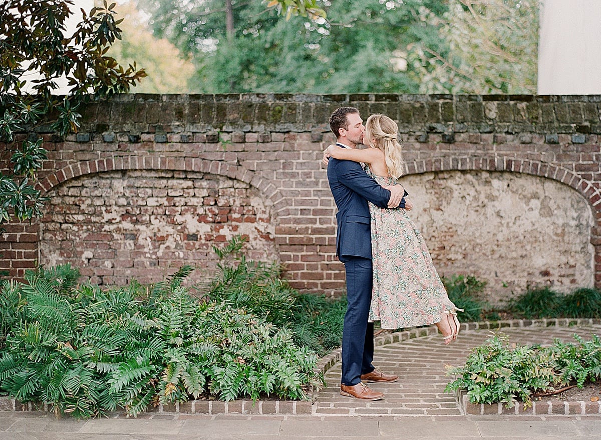Couple Kissing in Front of Brick Wall Photo