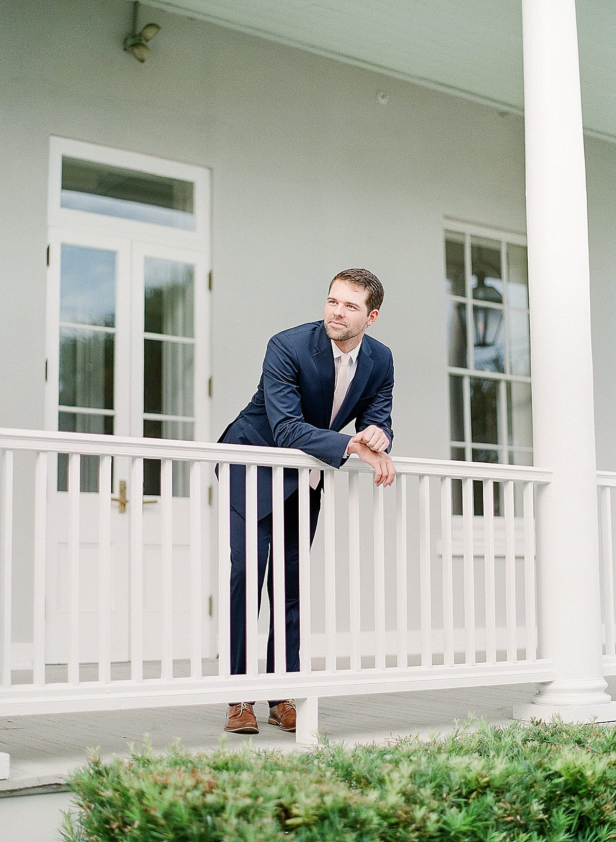 Groom Leaning Over Rail at Charleston SC Wedding Venue Gadsden House Photo