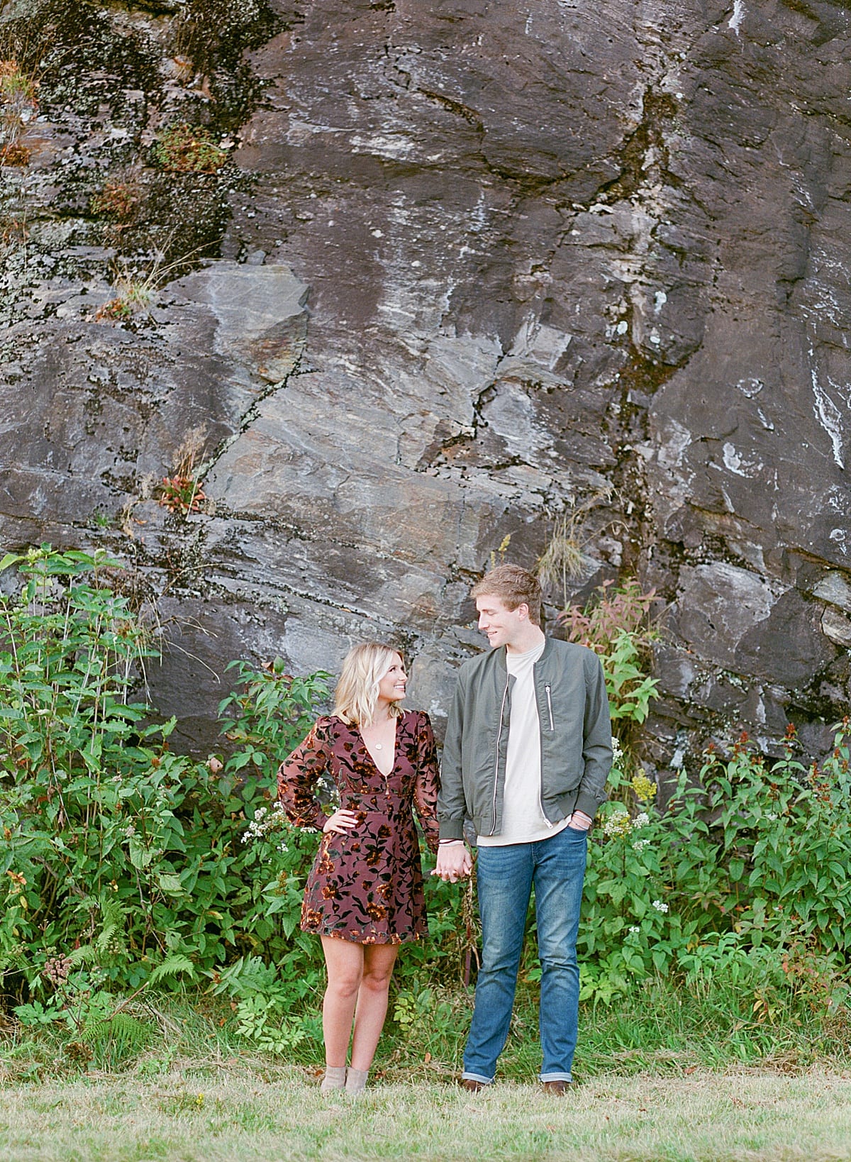 Couple Holding Hands in front of Rock Face Photo