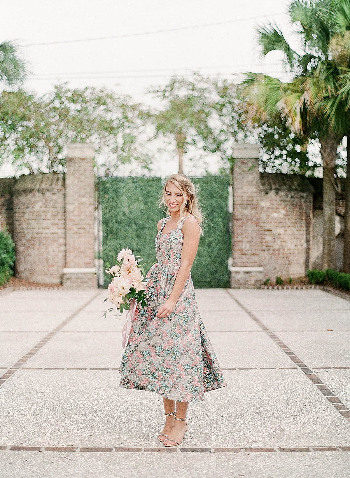 Girl Twirling in a Dress Holding Bouquet in Courtyard Photo