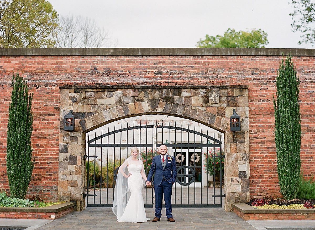 Bride and Groom Holding hands in front of Iron Gate Photo
