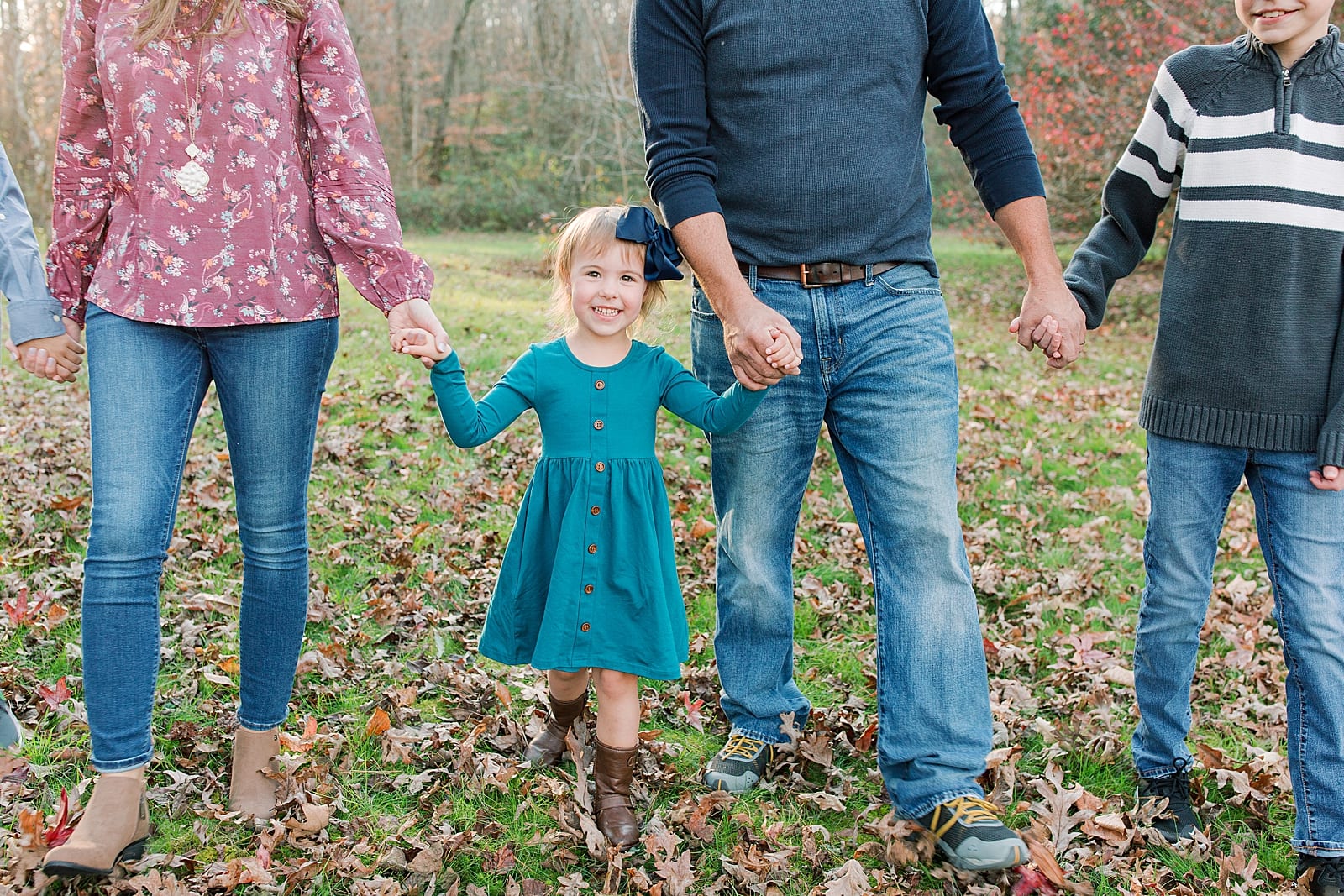 Little Girl Holding Parents Hands Walking Toward Camera Photo