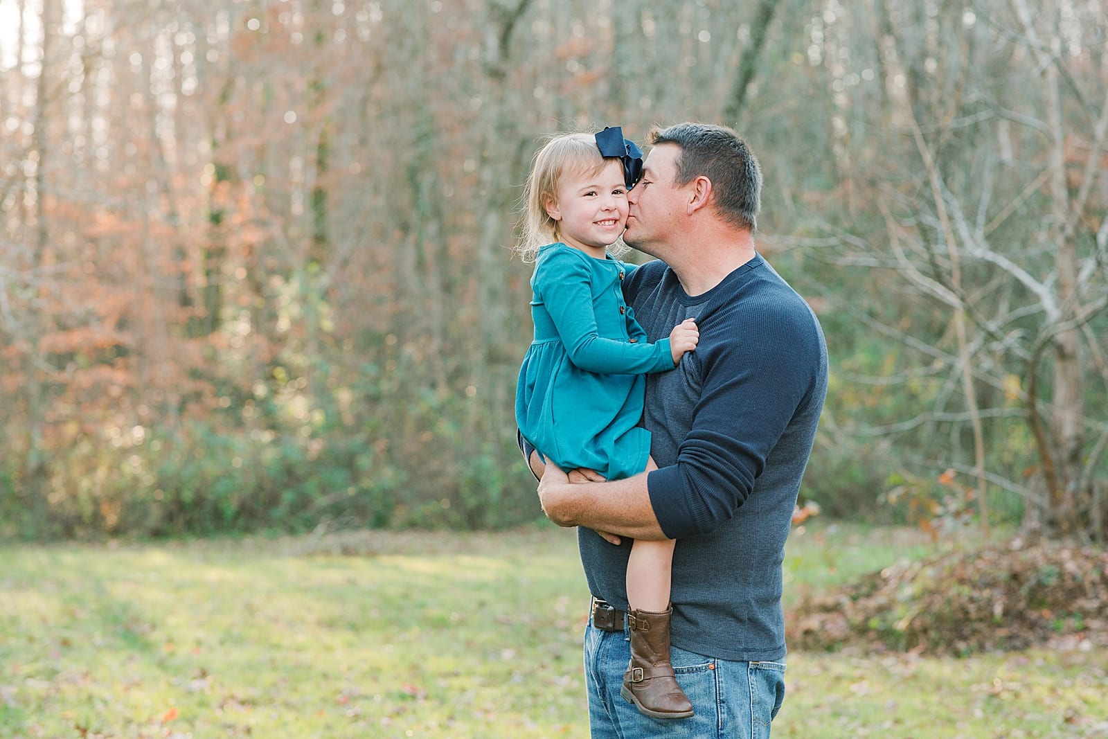 Father Holding Young Daughter and Kissing Her on the Cheek Photo
