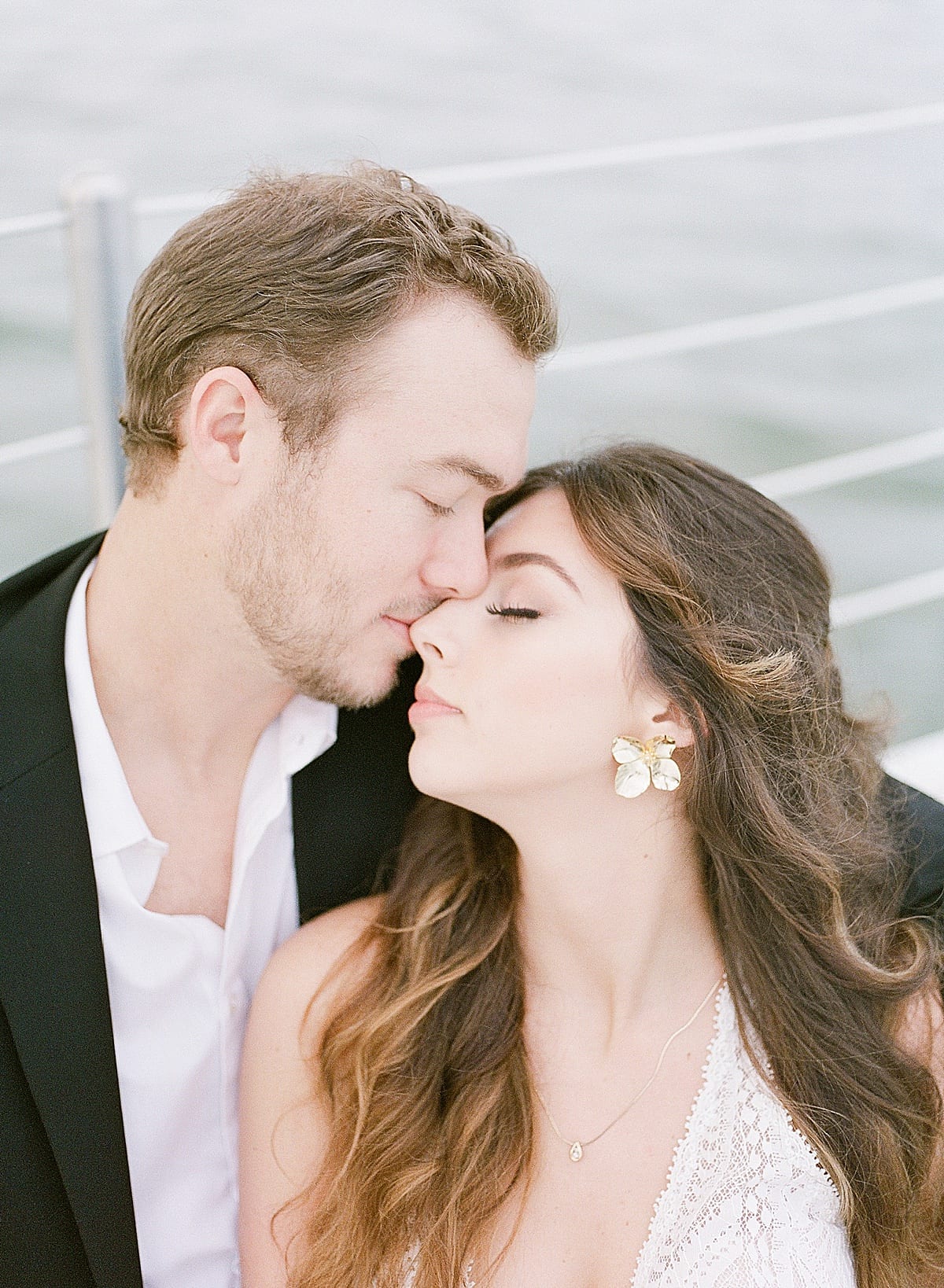 Bride and Groom Snuggling Nose to Nose on Sailboat Photo