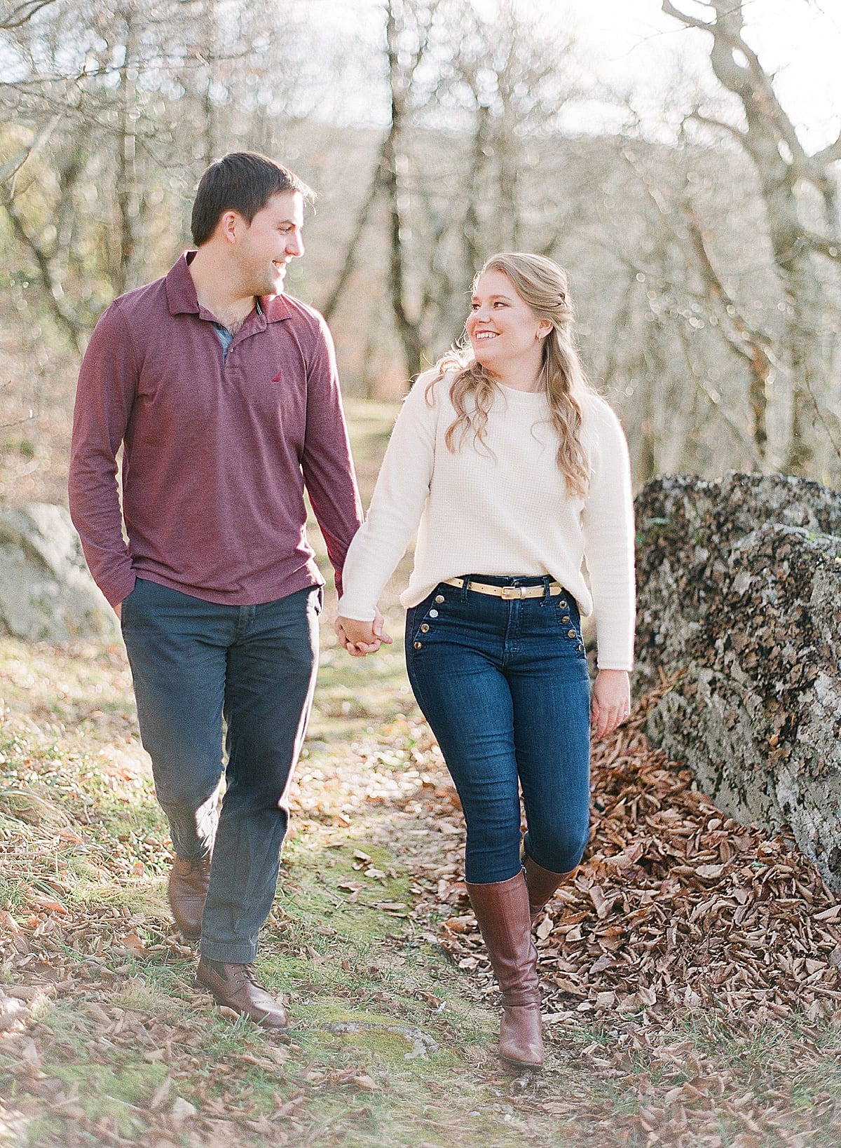 Mountaintop Engagement Session Couple Holding Hands Smiling at Each Other Walking Photo