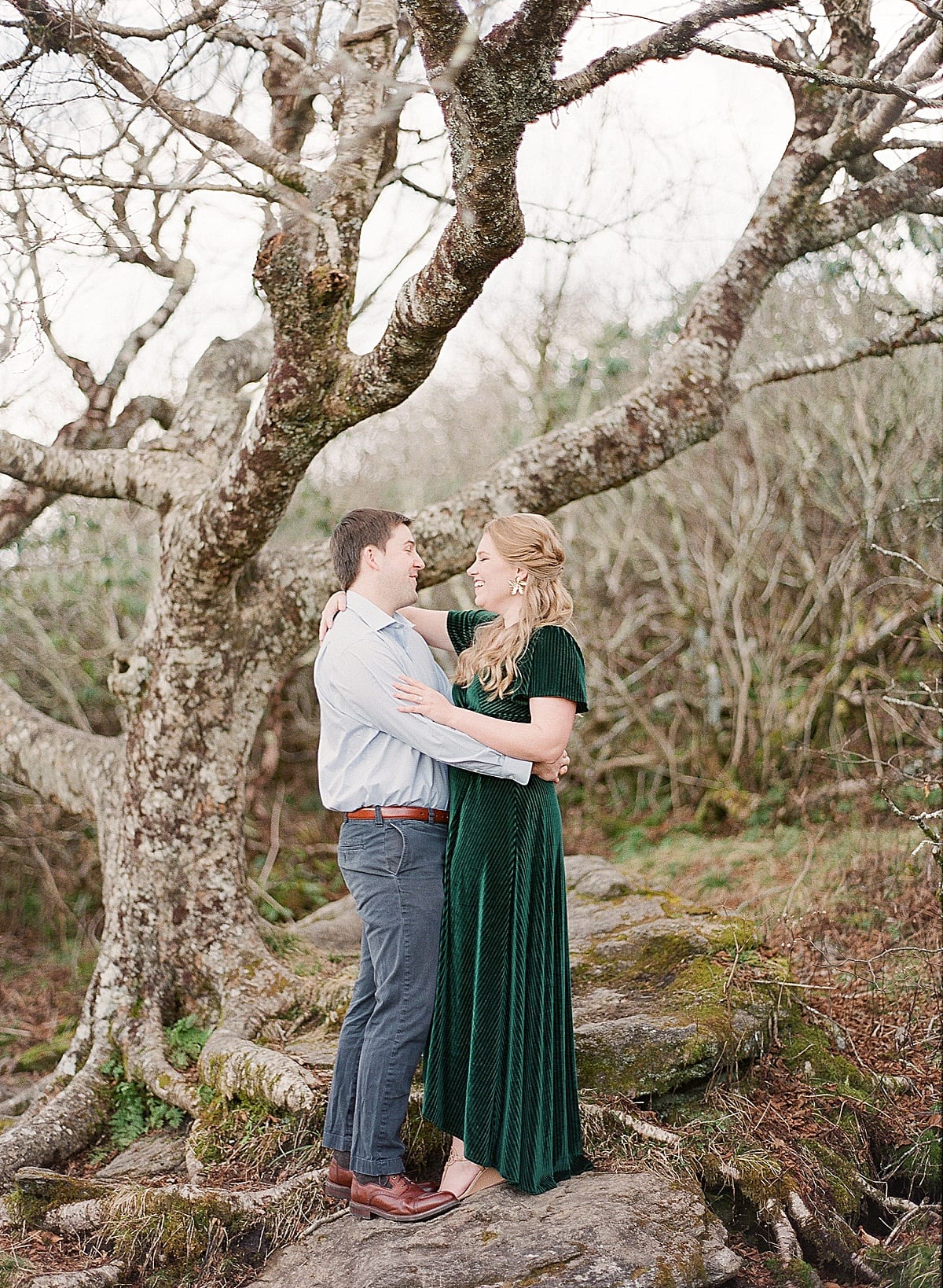 Couple Hugging and Smiling Under Tree Photo
