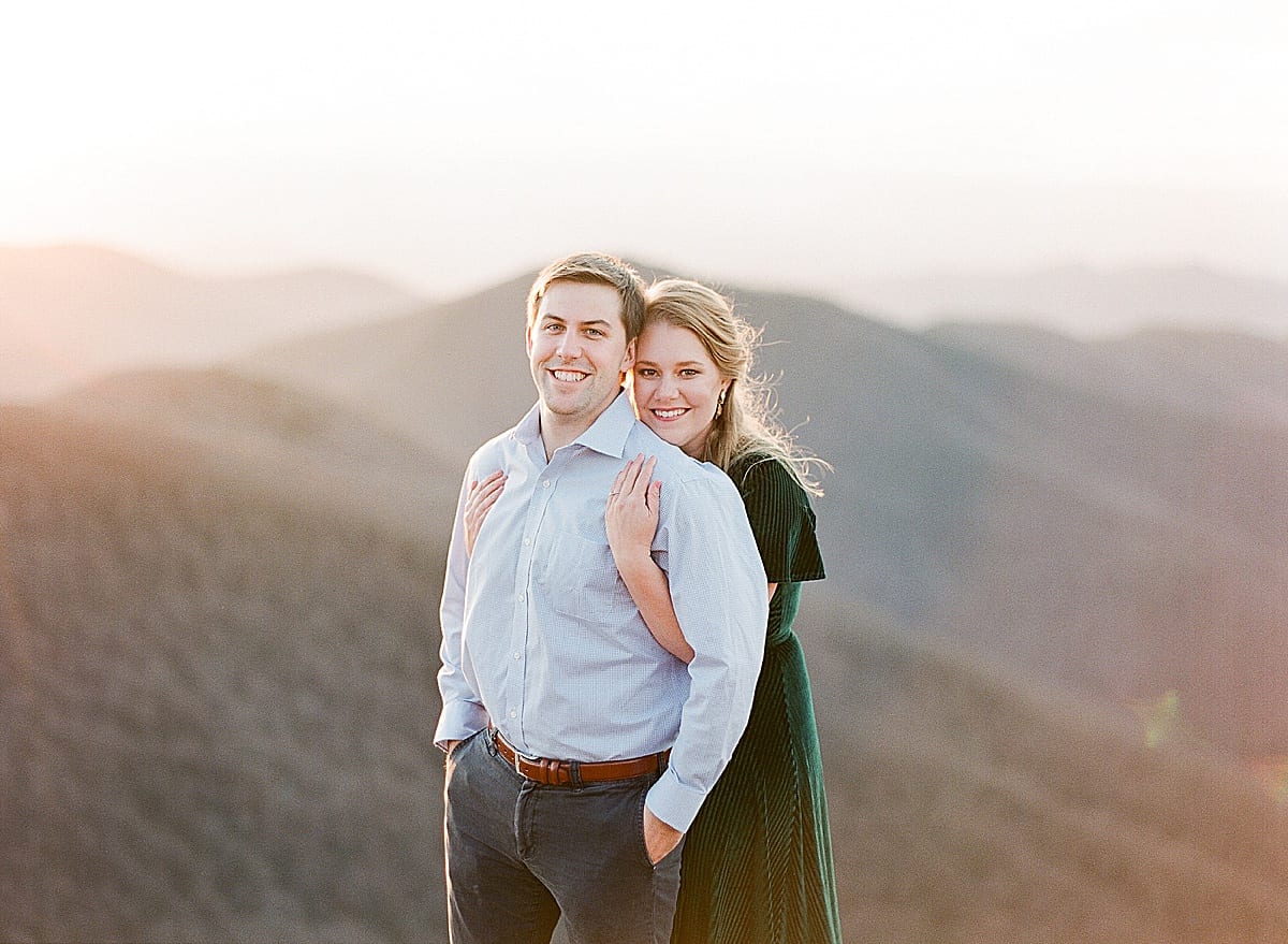 Mountaintop Engagement Session Couple Hugging Smiling at Camera Photo